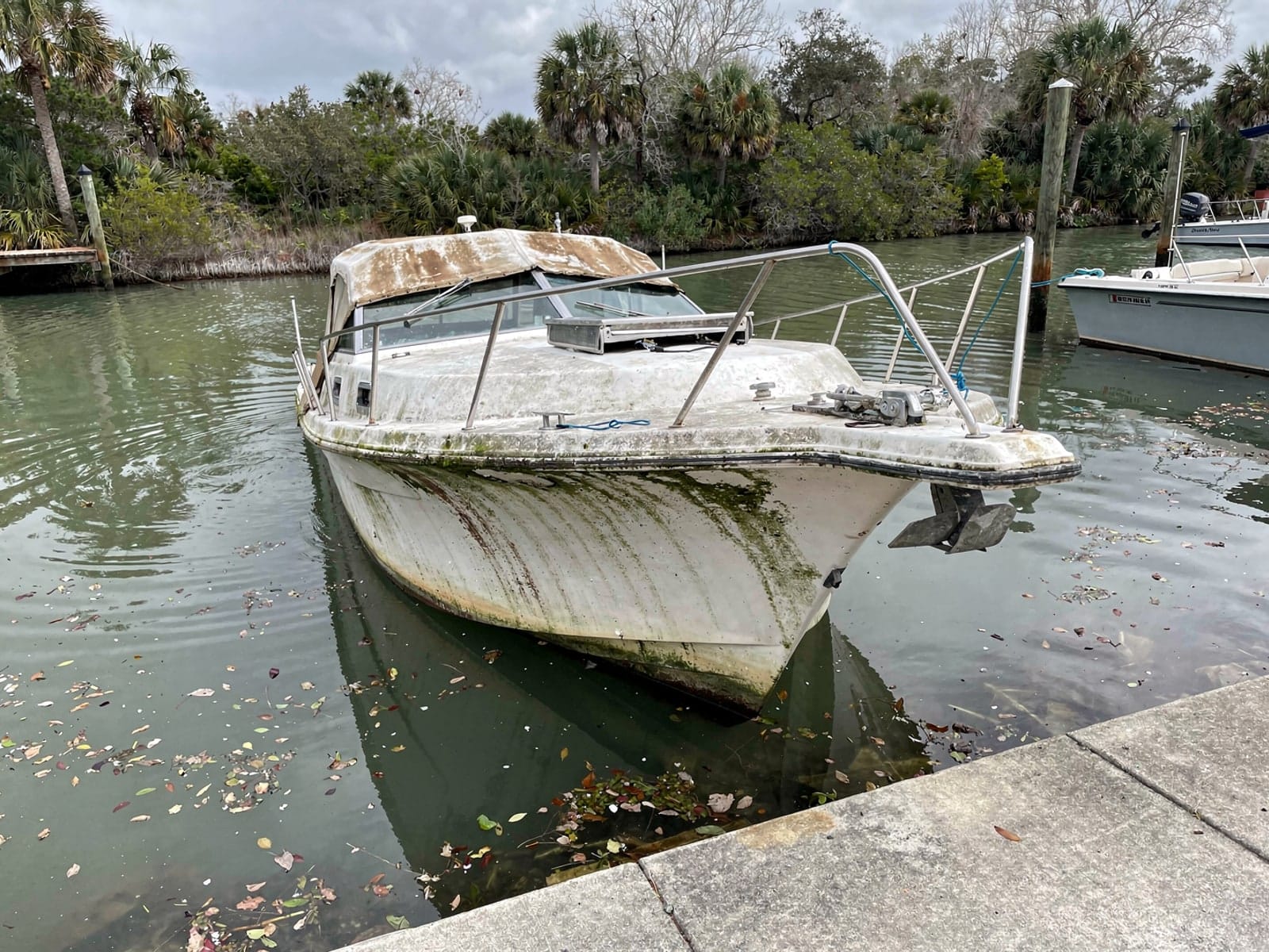Sunken boat recovery in Pensacola, FL: before Sunken 28 ft Bertram 28 by a boat ramp in Pensacola, FL