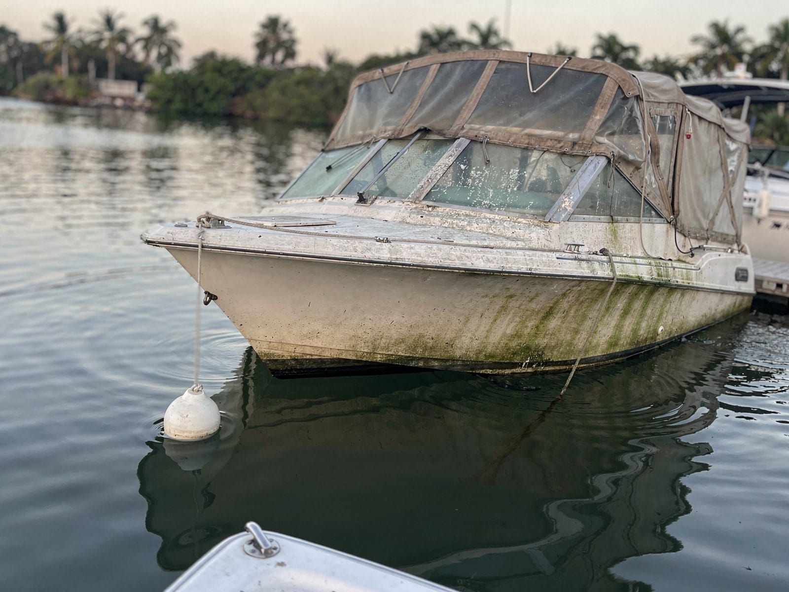 Sunken boat recovery in Viera West, FL: before Sunken 28 ft Carver 28 at its mooring in Viera West, FL
