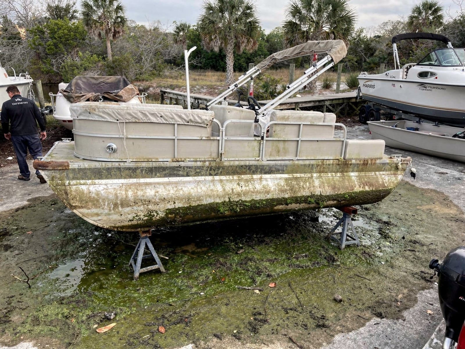 24 ft Harris FloteBote 24 from North Lauderdale, FL on stands at a repair yard after the recovery