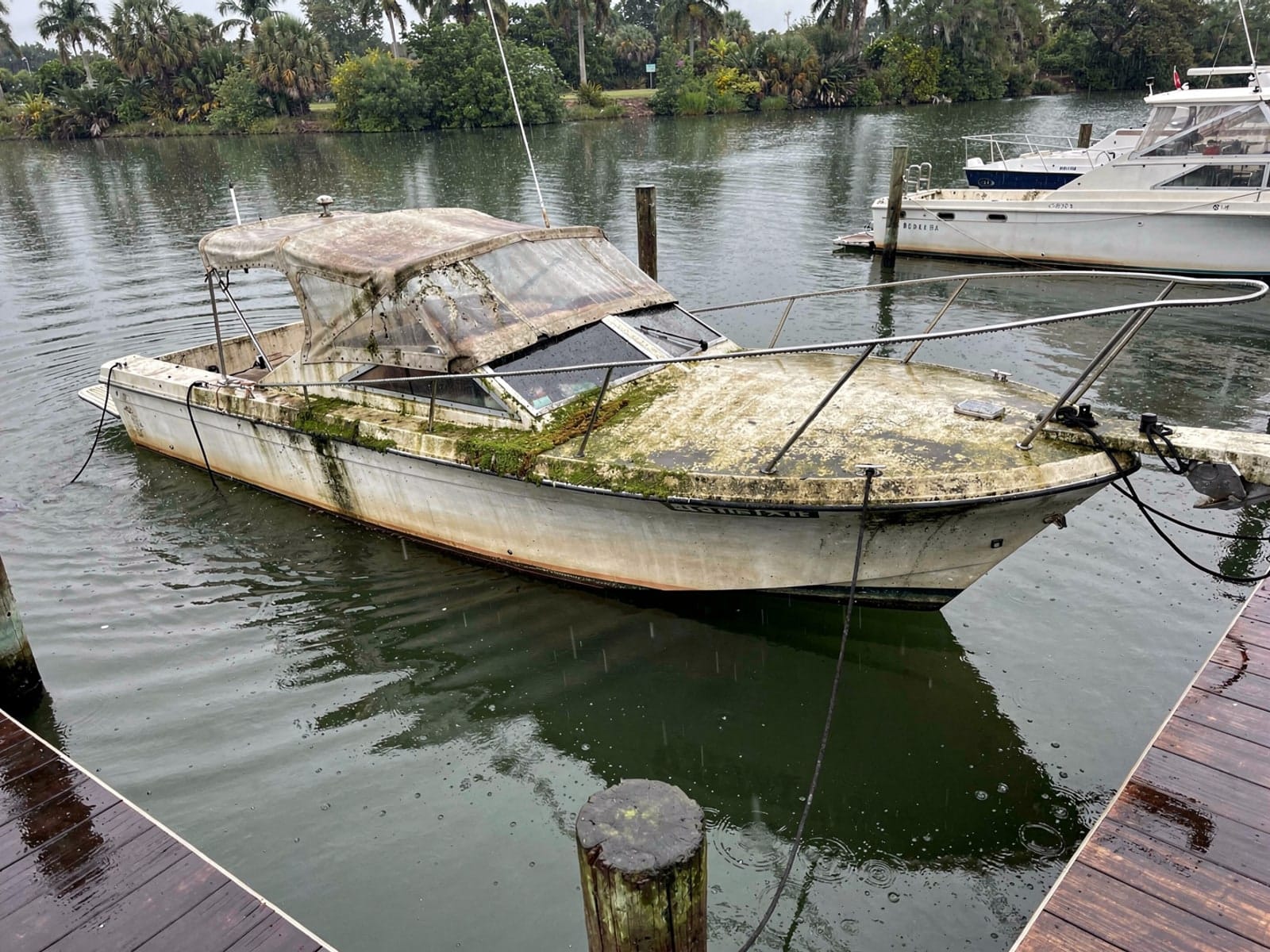 Sunken boat recovery in Oakland Park, FL: before Sunken 27 ft Chris-Craft Commander 27 at a lake dock in Oakland Park, FL