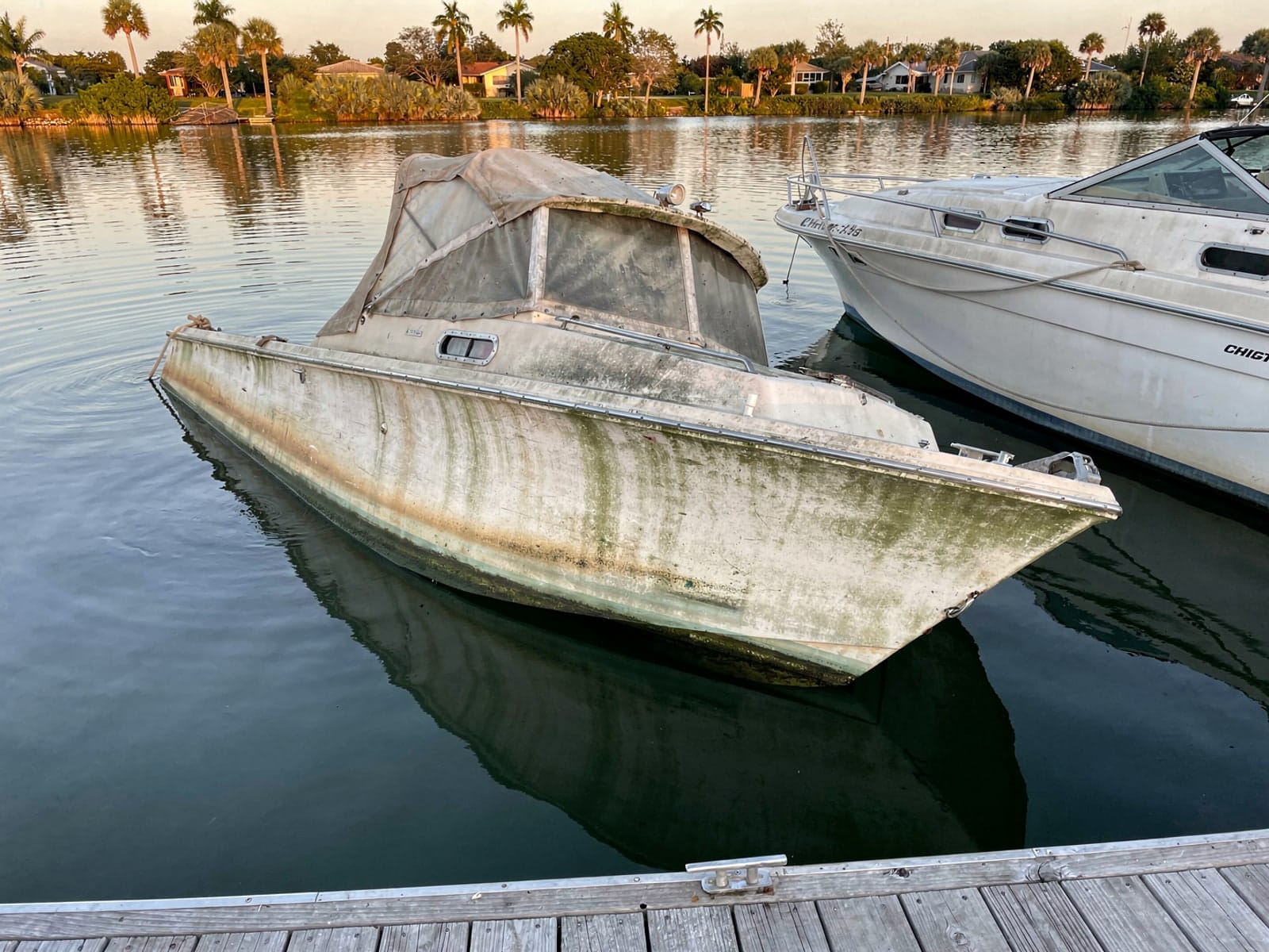 Sunken boat recovery in Orlando, FL: before Sunken 27 ft Chris-Craft Commander 27 at a lake dock in Orlando, FL