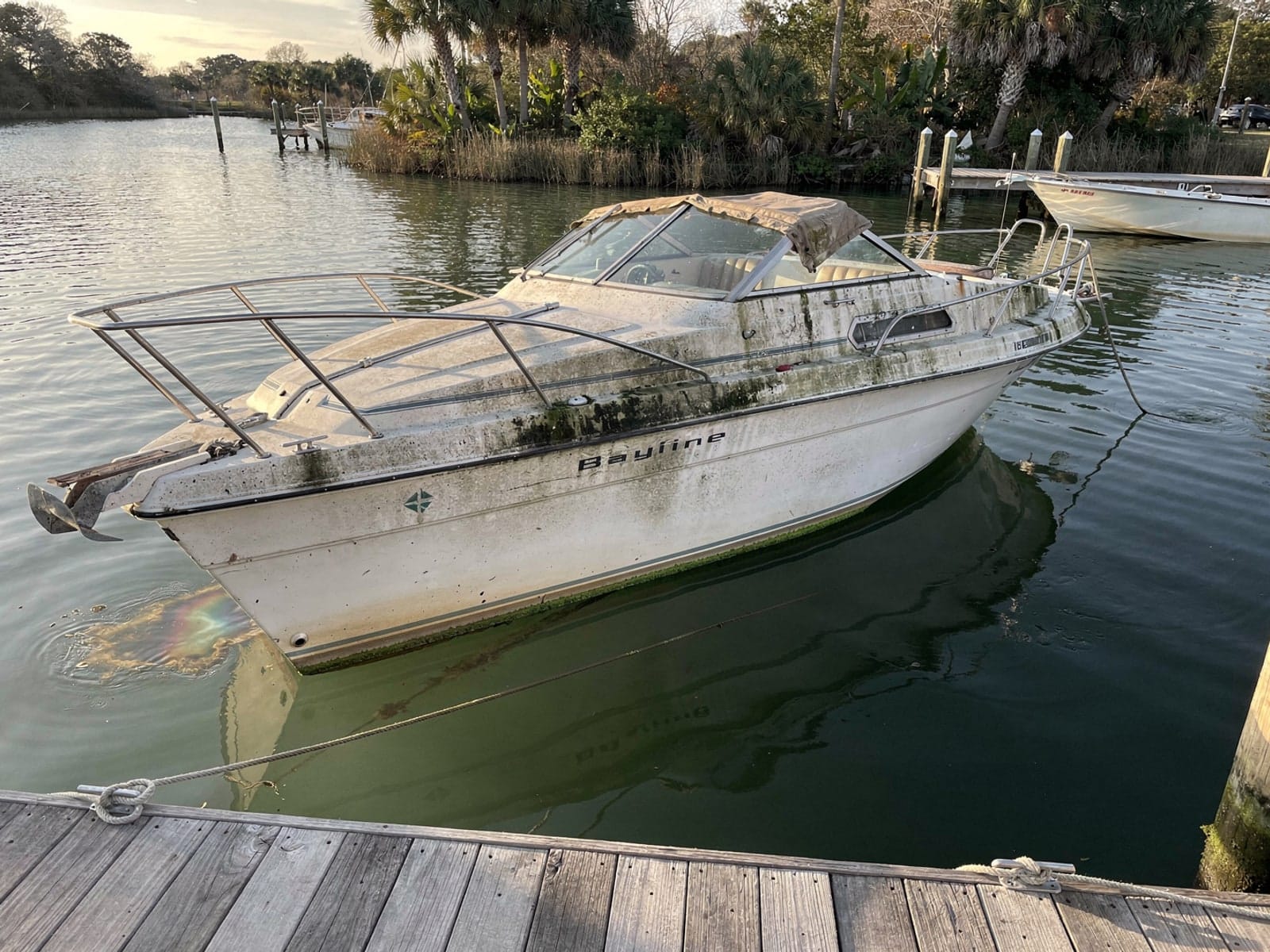 Sunken boat recovery in Palm Springs, FL: before Sunken 24 ft Bayliner 2455 Ciera at a lake dock in Palm Springs, FL