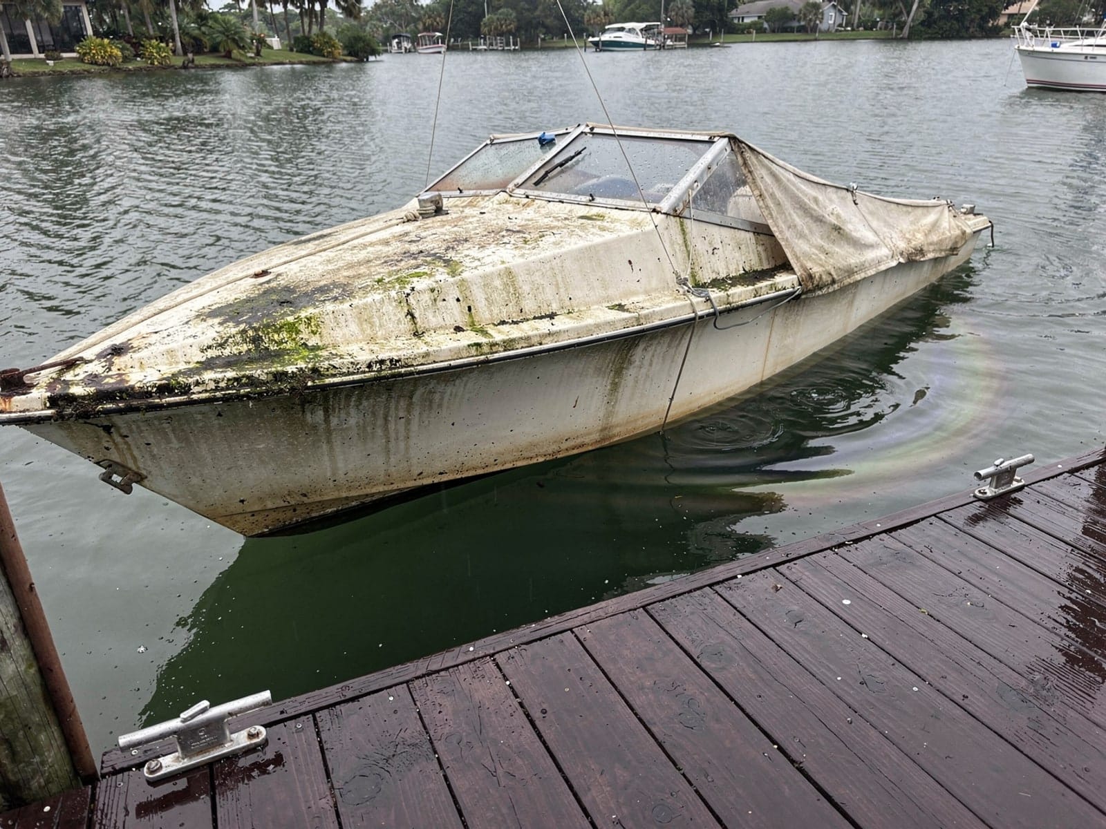 Sunken boat recovery in Parkland, FL: before Sunken 25 ft O'Day 25 at a lake dock in Parkland, FL