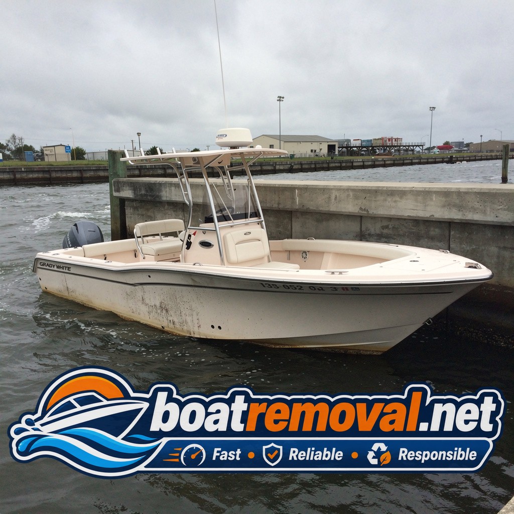 23-foot Grady-White center console listing against a seawall in Pascagoula, Mississippi after storm damage