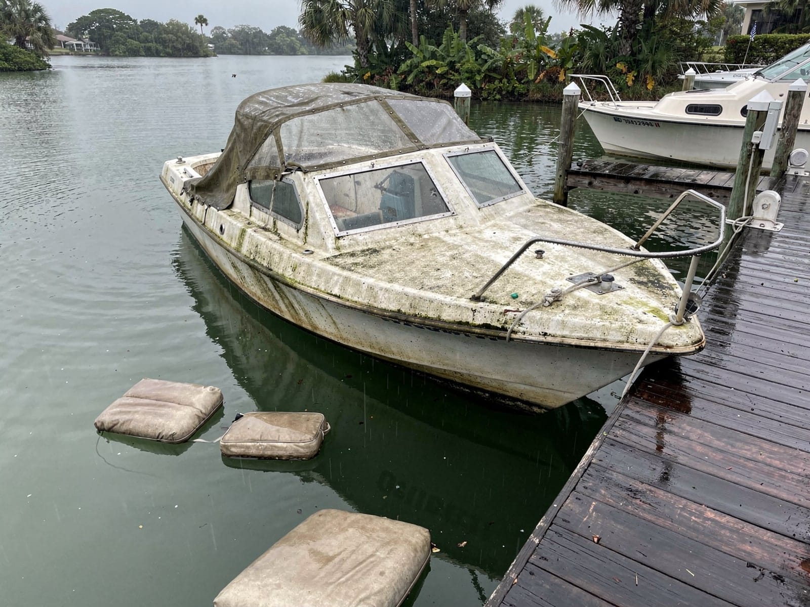 Sunken boat recovery in Pine Hills, FL: before Sunken 26 ft MacGregor 26 at a lake dock in Pine Hills, FL