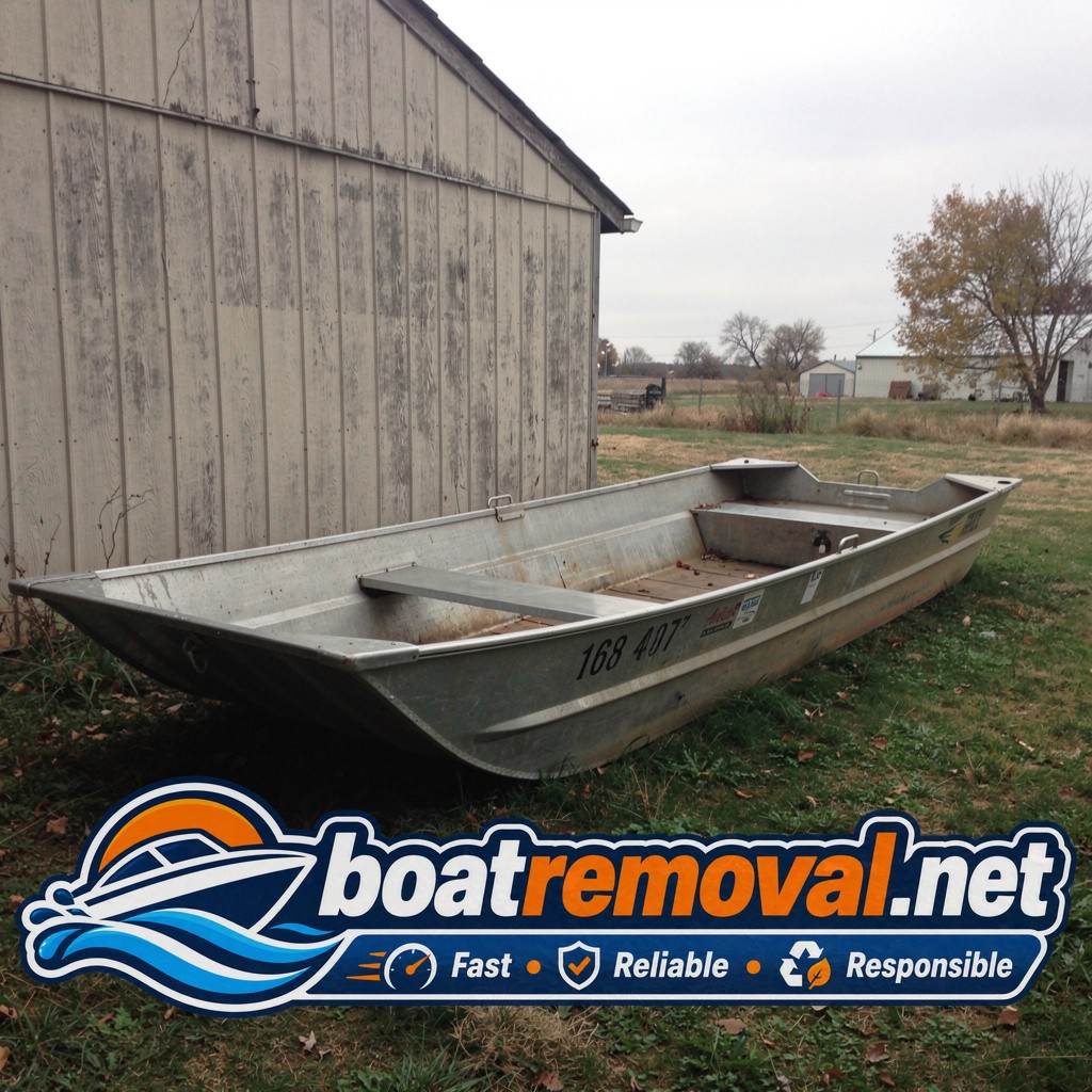 16-foot aluminum jon boat resting behind a shed near Plattsmouth, Nebraska before removal