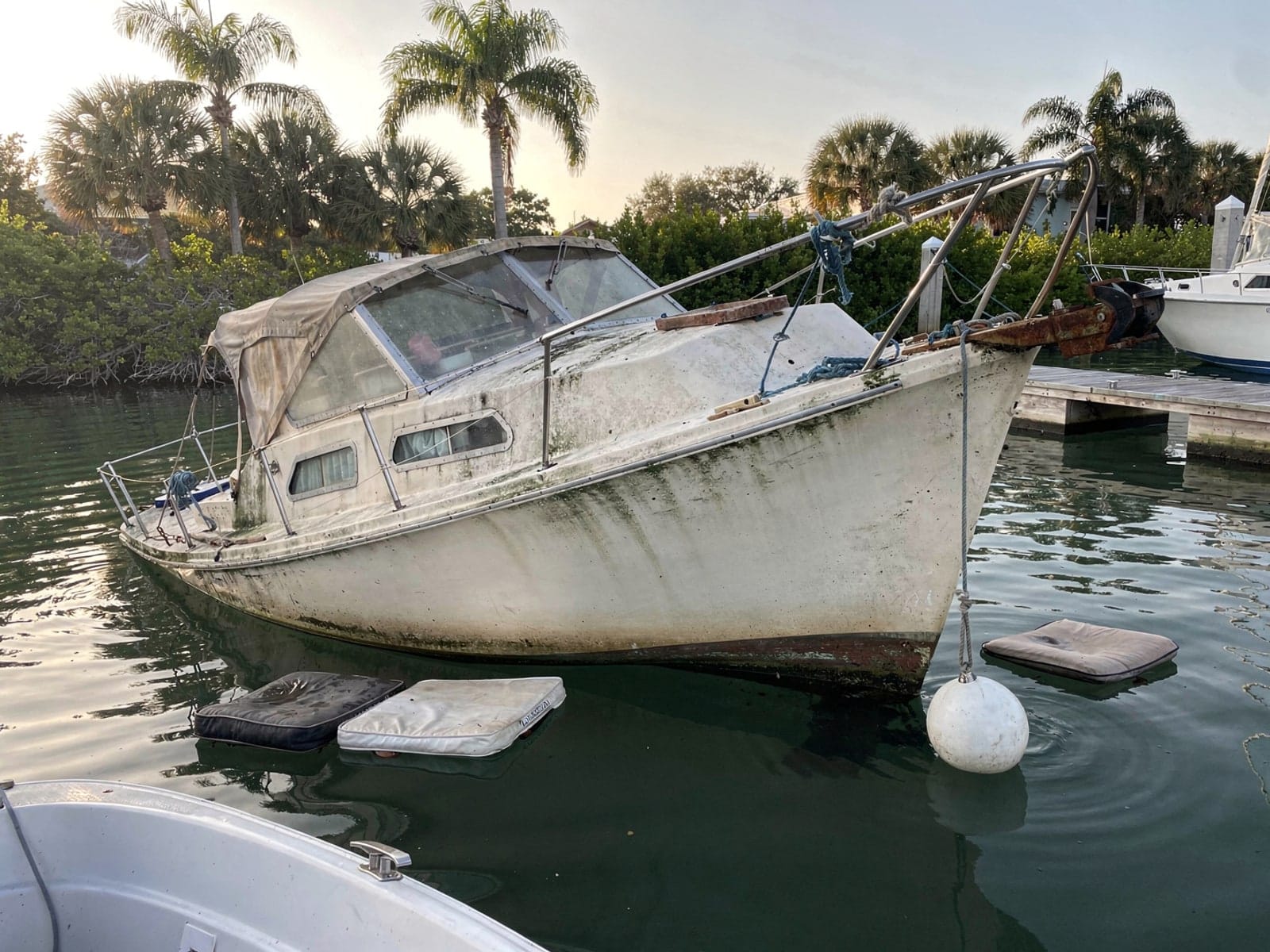 Sunken boat recovery in Poinciana, FL: before Sunken 27 ft Cal 27 at its mooring in Poinciana, FL