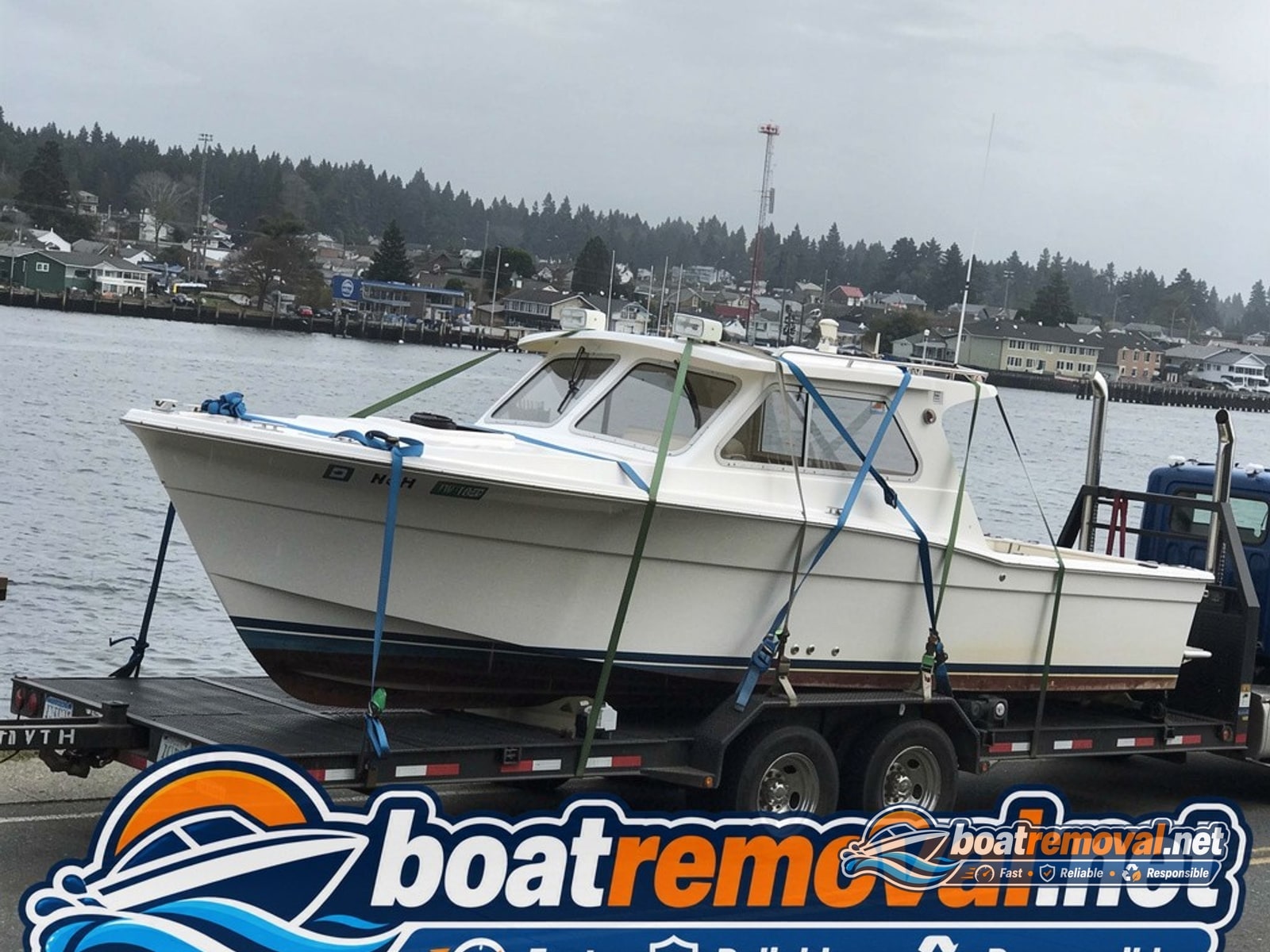 Port Townsend, WA: 30-foot Bertram sportfisherman loaded for removal Same sportfishing boat hull loaded onto a barge after being raised from shallow water