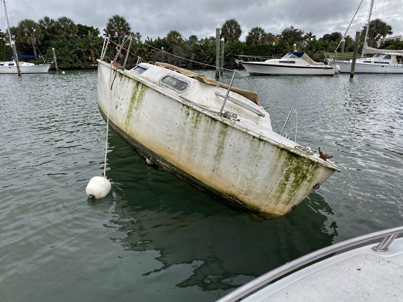 Sunken boat recovery in Princeton, FL: before Sunken 26 ft Pearson 26 at its mooring in Princeton, FL