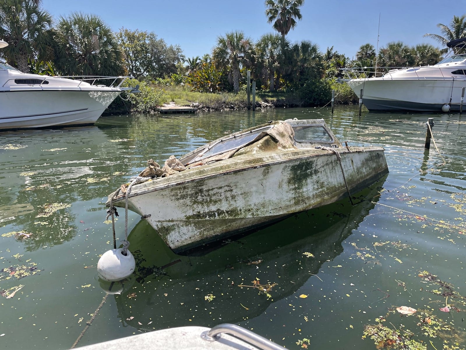 Sunken boat recovery in Richmond West, FL: before Sunken 21 ft Thompson 21 at its mooring in Richmond West, FL