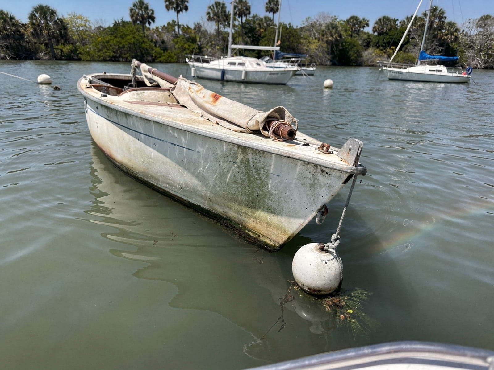 Sunken boat recovery in Riviera Beach, FL: before Sunken 22 ft Catalina 22 at its mooring in Riviera Beach, FL