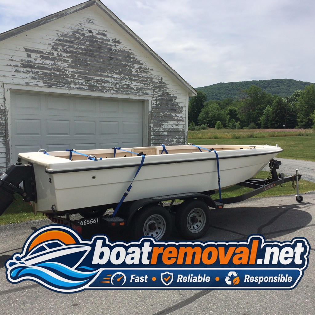 Same bowrider boat loaded onto a trailer on wet ground with support boards visible