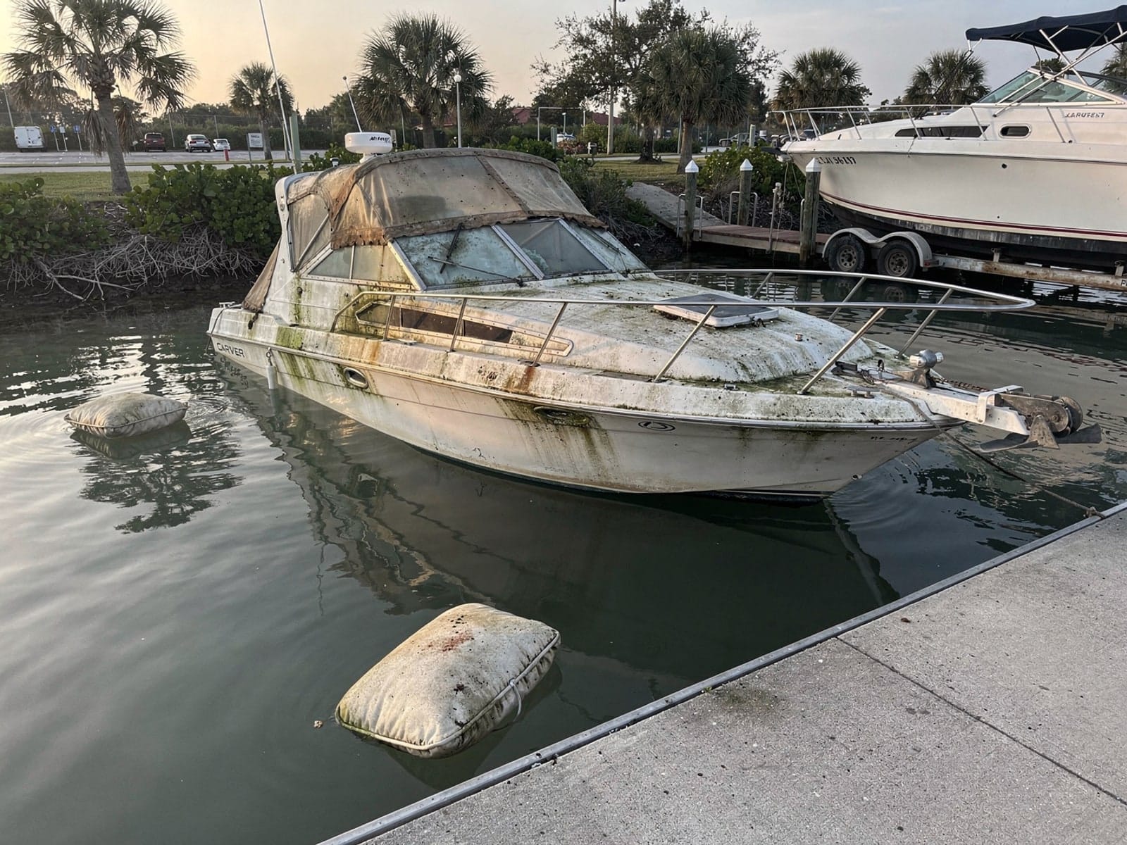 Sunken boat recovery in Sarasota, FL: before Sunken 28 ft Carver 28 by a boat ramp in Sarasota, FL