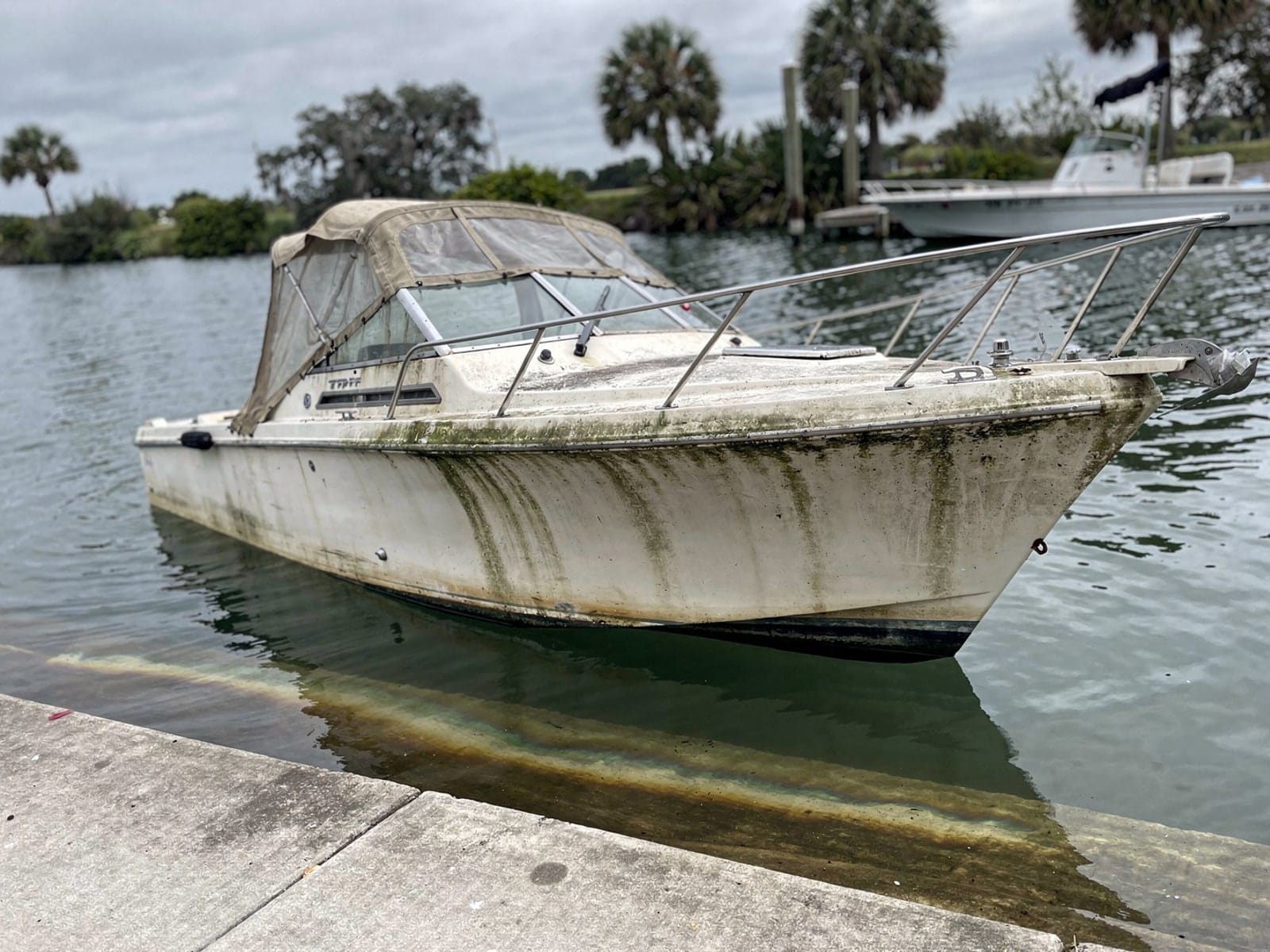Sunken boat recovery in Southchase, FL: before Sunken 23 ft Chris-Craft Cavalier by a boat ramp in Southchase, FL