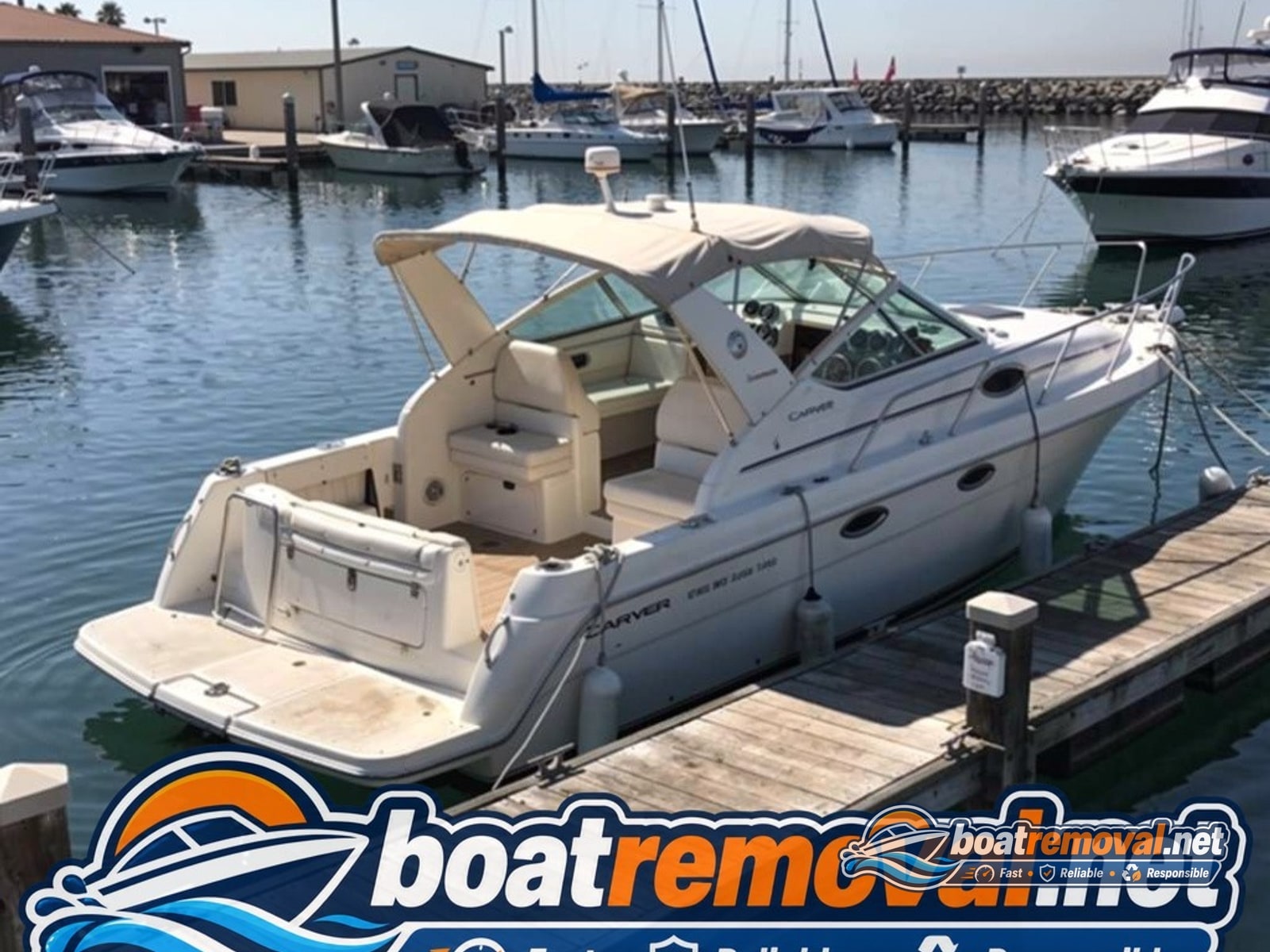 28-foot Carver cabin cruiser partially swamped and listing at a marina dock in Port Hueneme, California