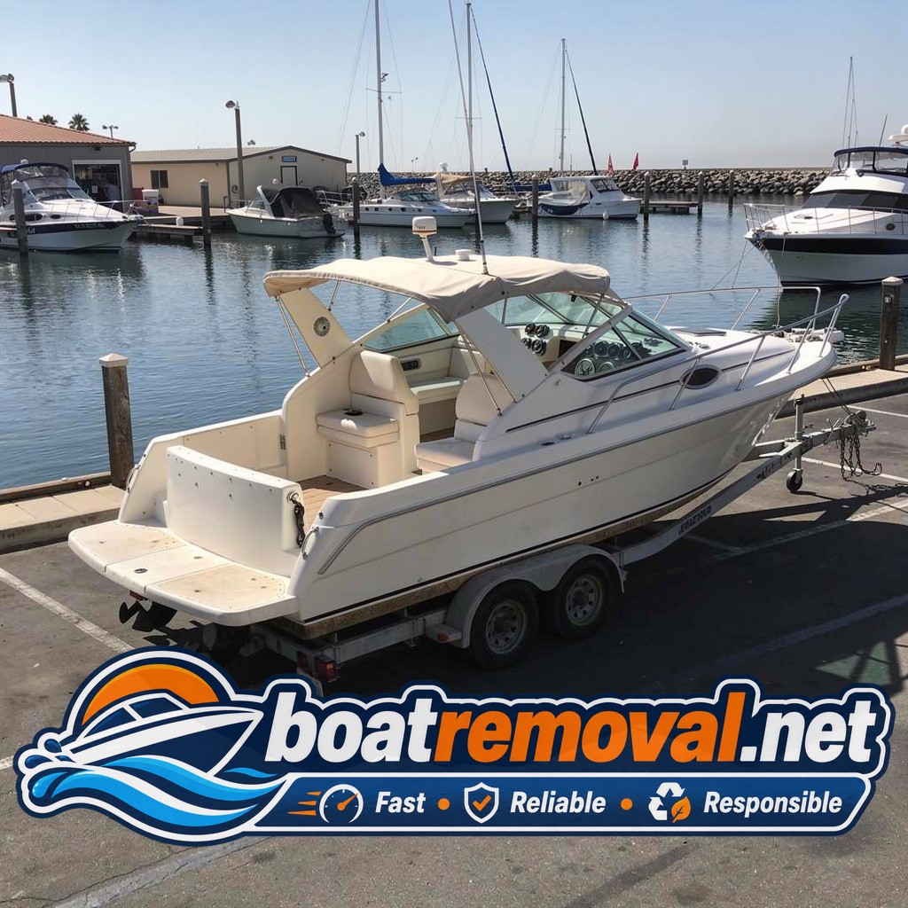 Carver cabin cruiser loaded onto a trailer after storm removal in Port Hueneme, California