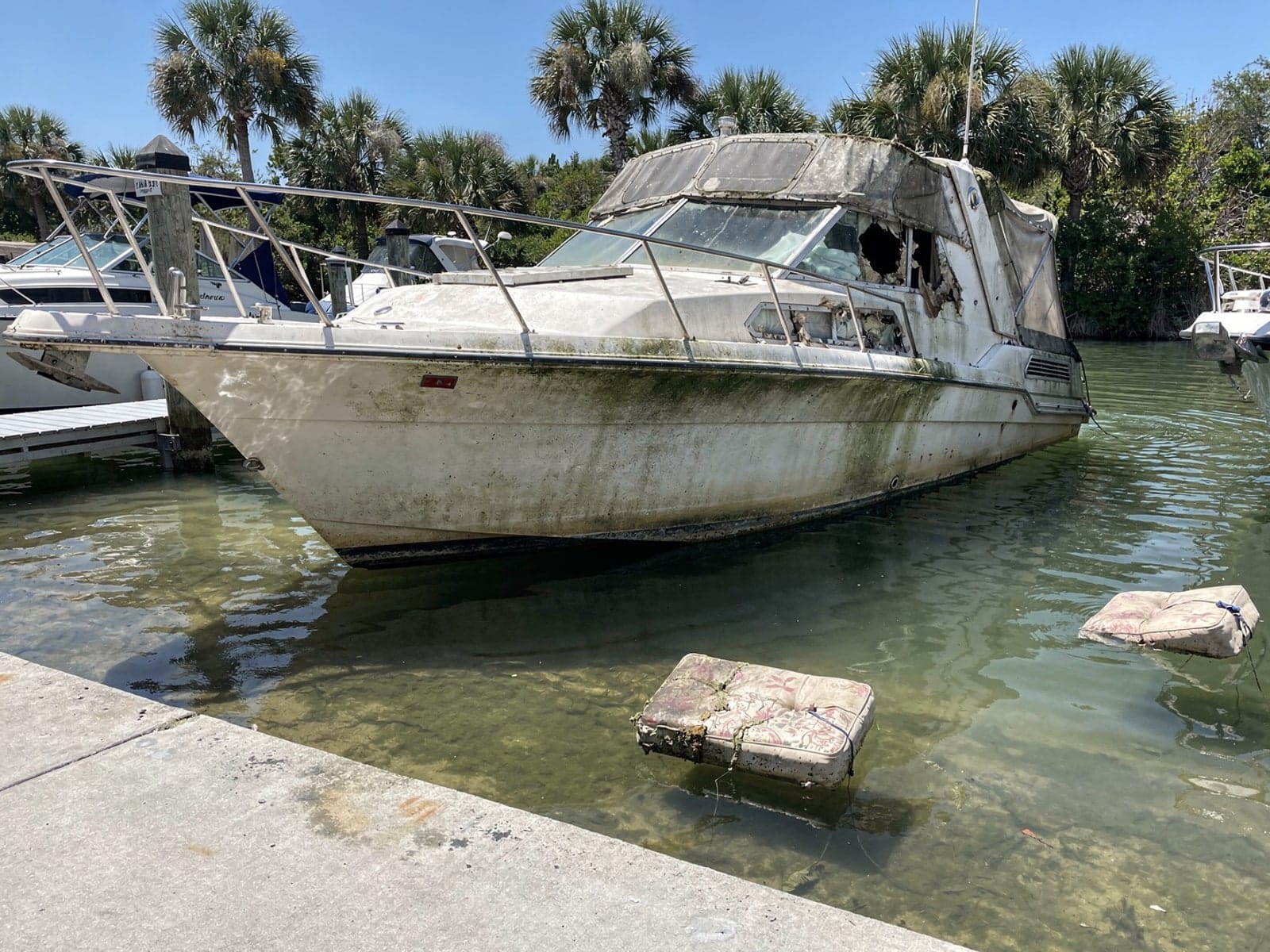 Sunken boat recovery in Brent, FL: before Sunken 28 ft Carver 28 by a boat ramp in Brent, FL