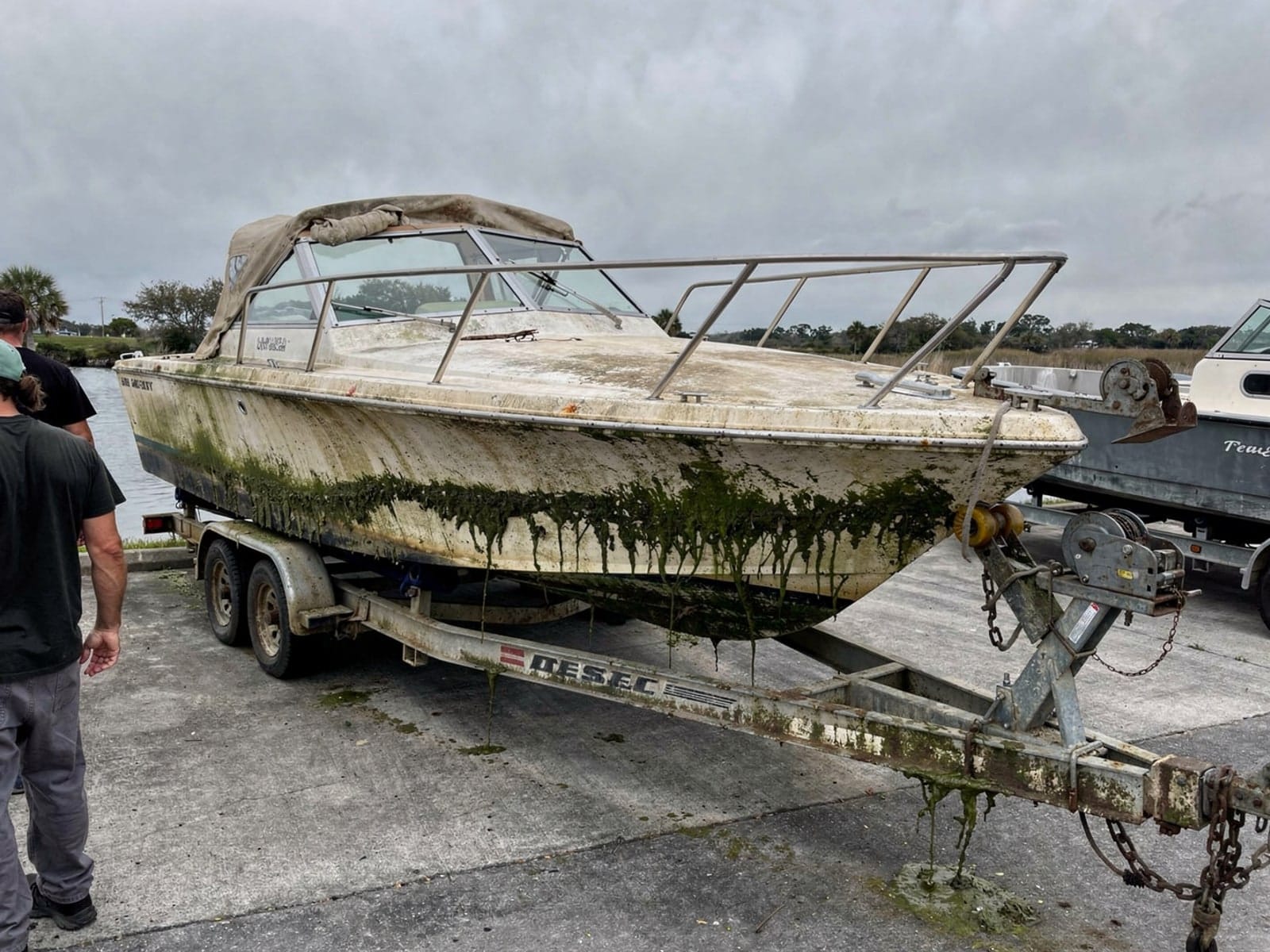 Sunken boat recovery in Debary, FL: pulled out at the ramp 27 ft Chris-Craft Commander 27 pulled out on a trailer at a Debary, FL boat ramp