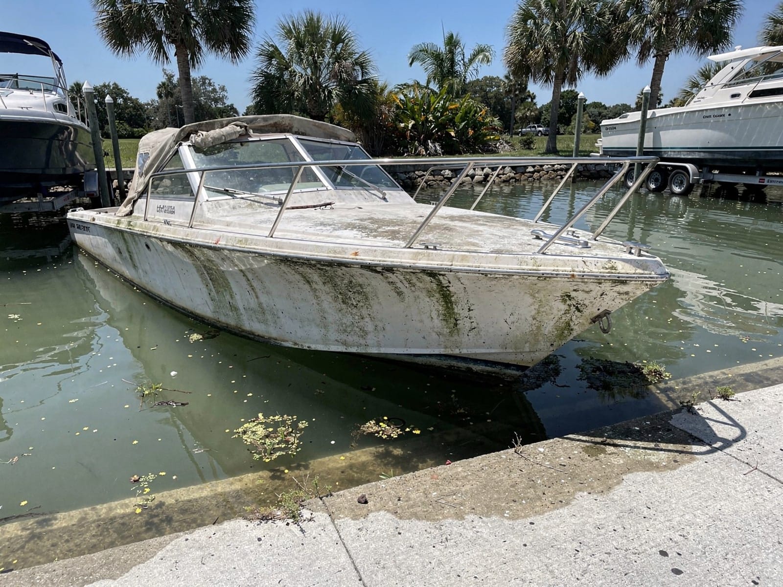 Sunken boat recovery in Debary, FL: before Sunken 27 ft Chris-Craft Commander 27 by a boat ramp in Debary, FL