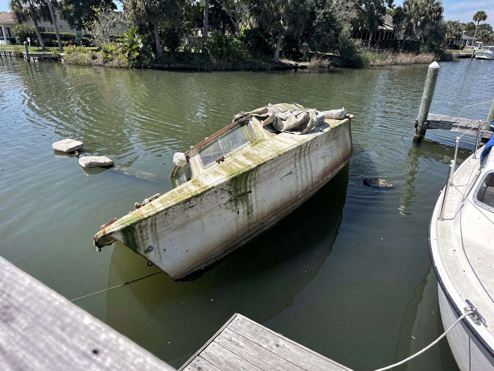 Sunken boat recovery in Ocoee, FL: before Sunken 26 ft Pearson 26 at a lake dock in Ocoee, FL