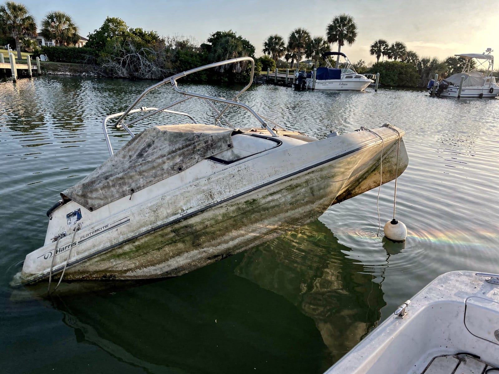 Sunken boat recovery in Key West, FL: before Sunken 24 ft Harris FloteBote 24 at its mooring in Key West, FL