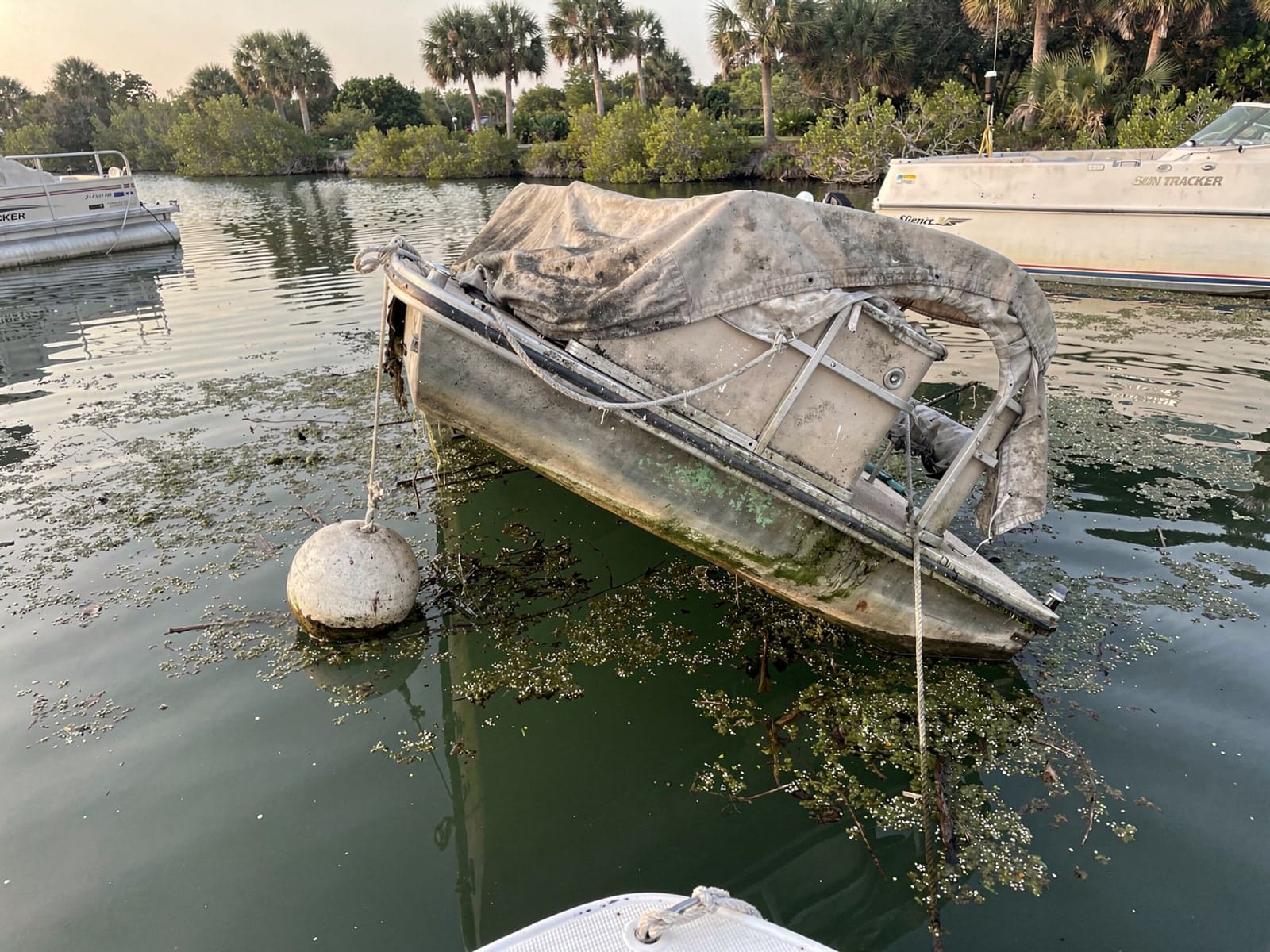 Sunken boat recovery in Leisure City, FL: before Sunken 22 ft Sun Tracker Party Barge 22 at its mooring in Leisure City, FL