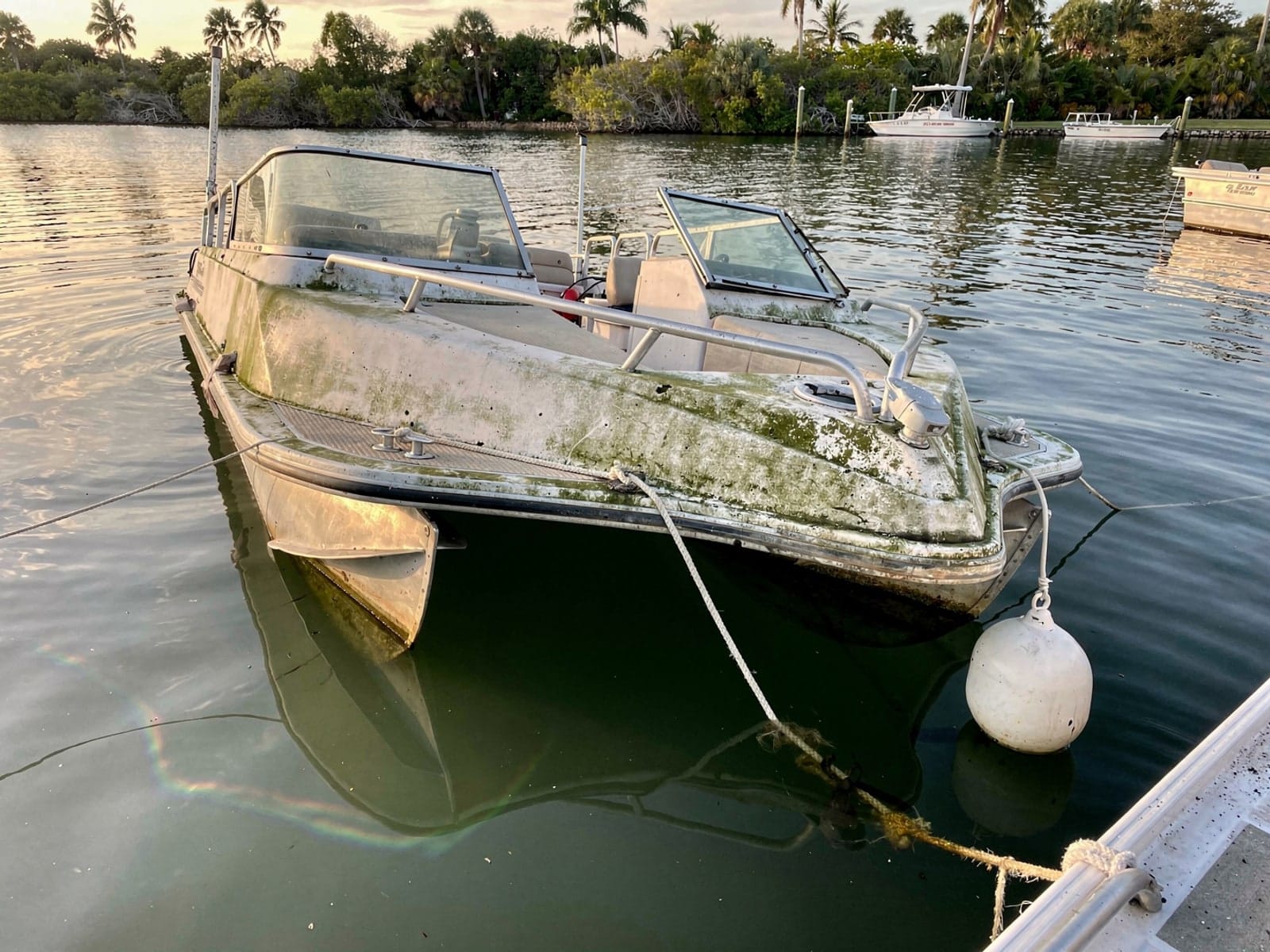 Sunken boat recovery in Sanford, FL: before Sunken 22 ft Sun Tracker Party Barge 22 at its mooring in Sanford, FL
