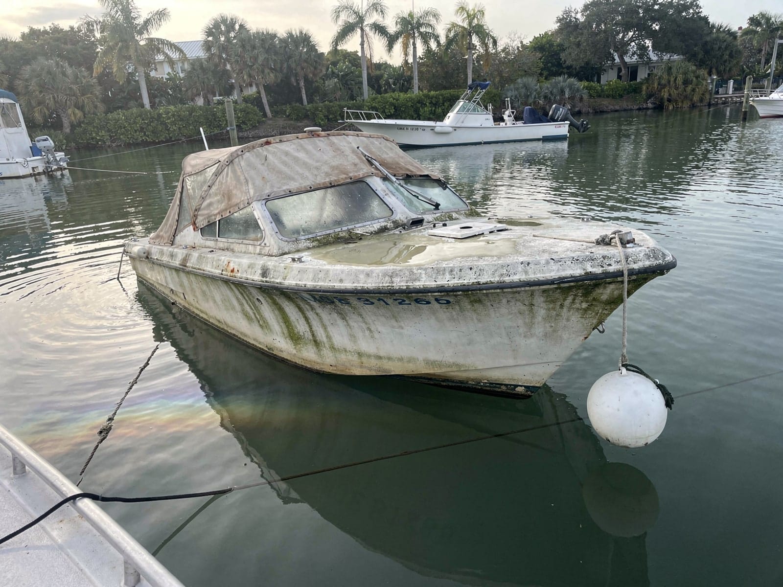 Sunken boat recovery in Tamiami, FL: before Sunken 22 ft Larson 220 at its mooring in Tamiami, FL