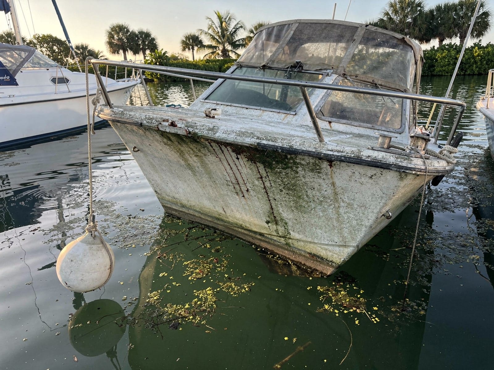 Sunken boat recovery in Asbury Lake, FL: before Sunken 25 ft O'Day 25 at its mooring in Asbury Lake, FL