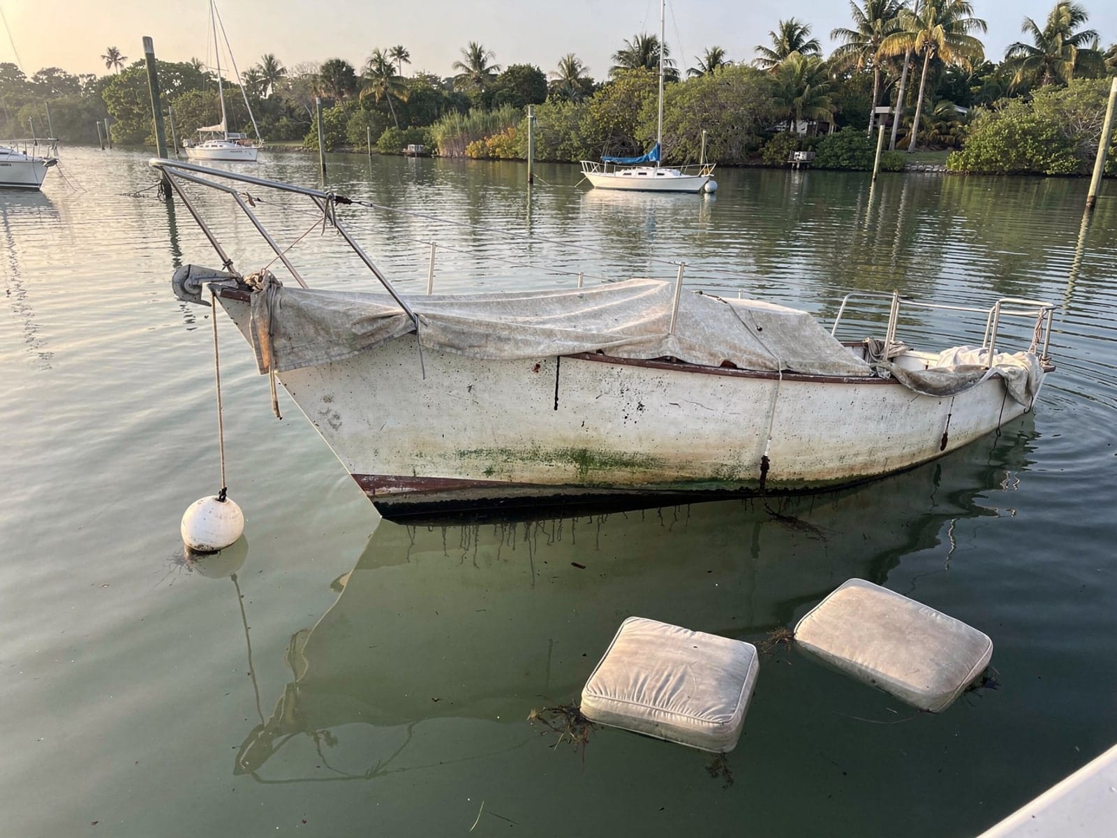 Sunken boat recovery in Ensley, FL: before Sunken 25 ft O'Day 25 at its mooring in Ensley, FL