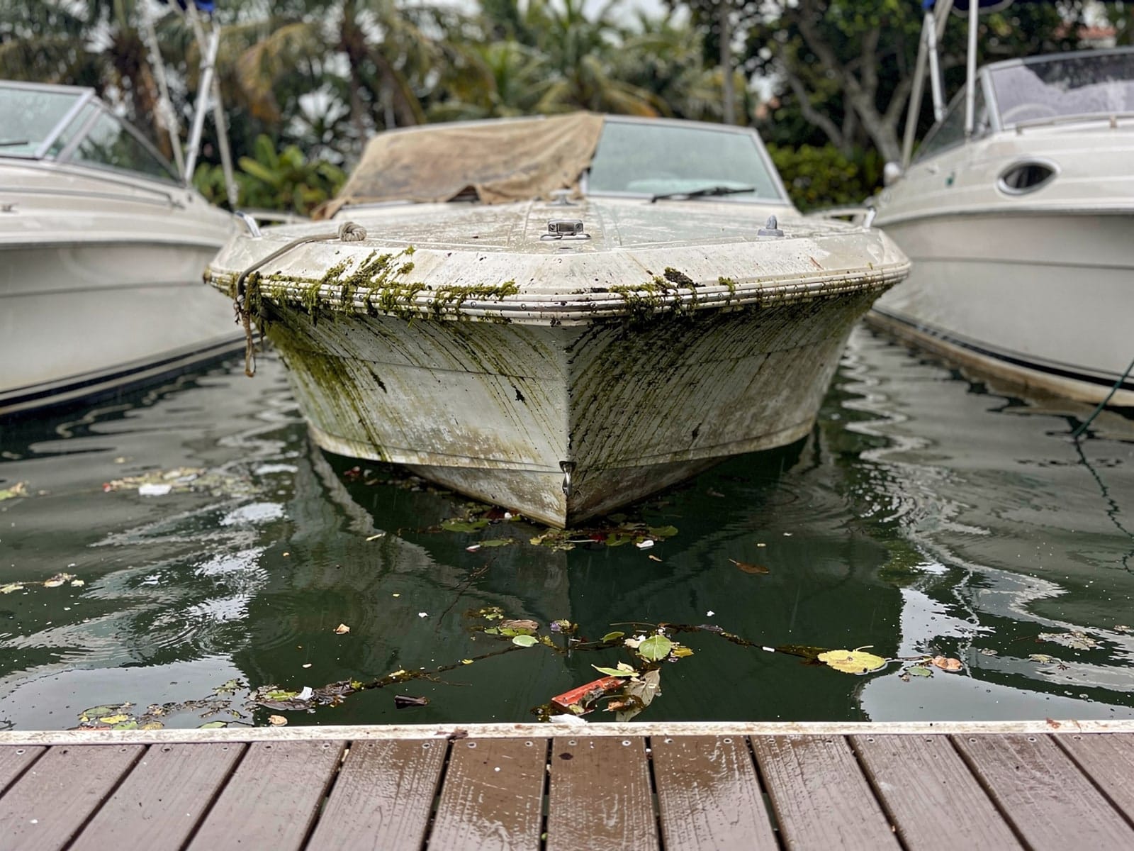 Sunken boat recovery in Golden Glades, FL: before Sunken 23 ft Rinker 232 in a marina slip in Golden Glades, FL
