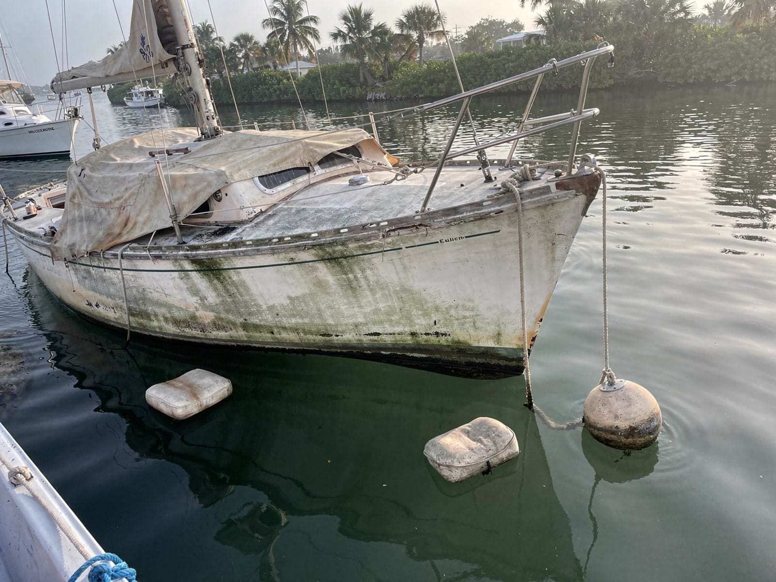 Sunken boat recovery in Kendall, FL: before Sunken 26 ft Pearson 26 at its mooring in Kendall, FL