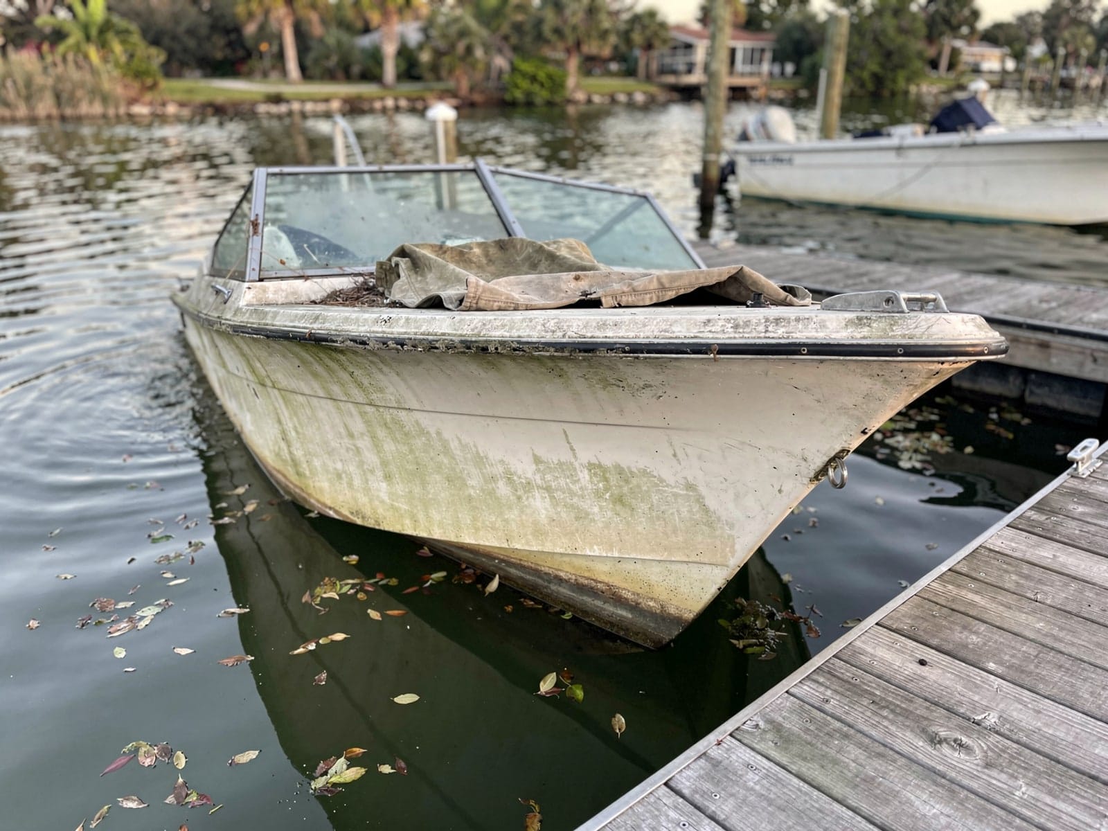 Sunken boat recovery in Kissimmee, FL: before Sunken 21 ft Thompson 21 at a lake dock in Kissimmee, FL