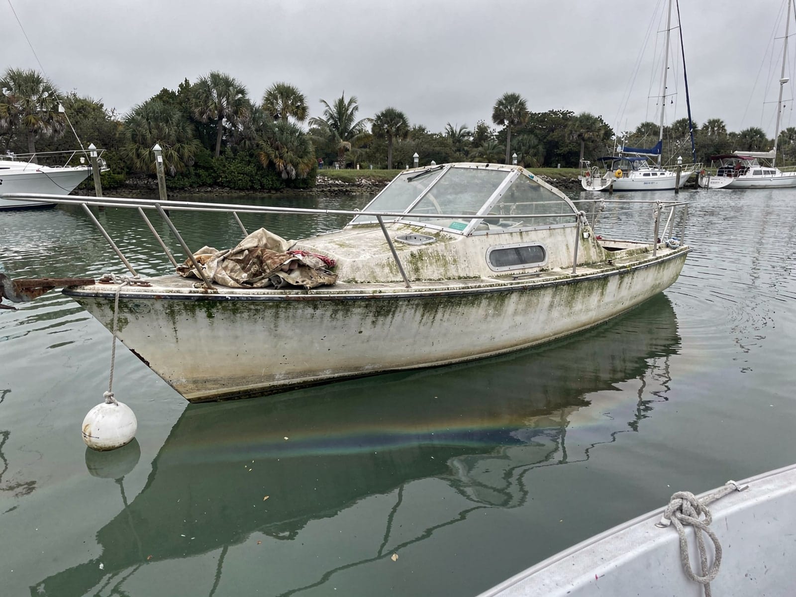 Sunken boat recovery in Pace, FL: before Sunken 27 ft Cal 27 at its mooring in Pace, FL