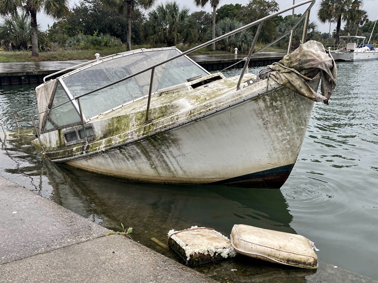 Sunken boat recovery in Riverview, FL: before Sunken 27 ft Ericson 27 by a boat ramp in Riverview, FL