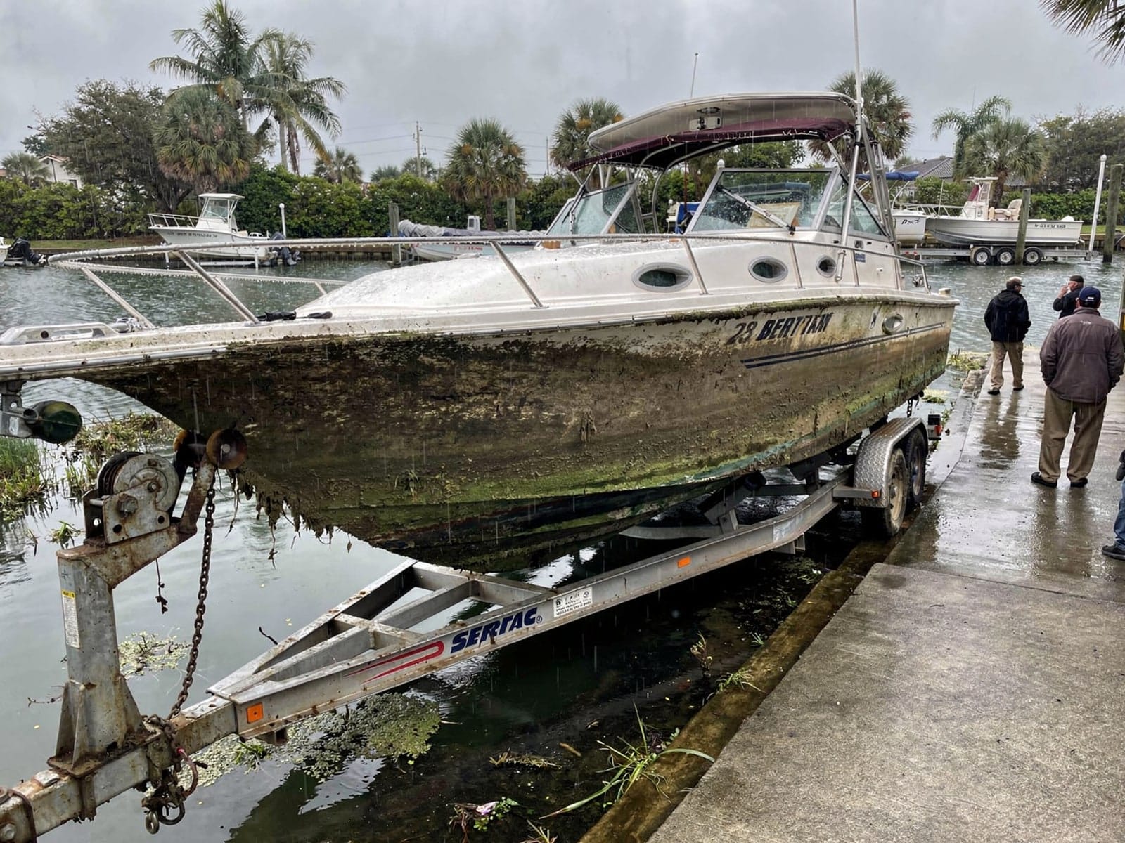 Sunken boat recovery in Greenacres, FL: pulled out at the ramp 28 ft Bertram 28 pulled out on a trailer at a Greenacres, FL boat ramp