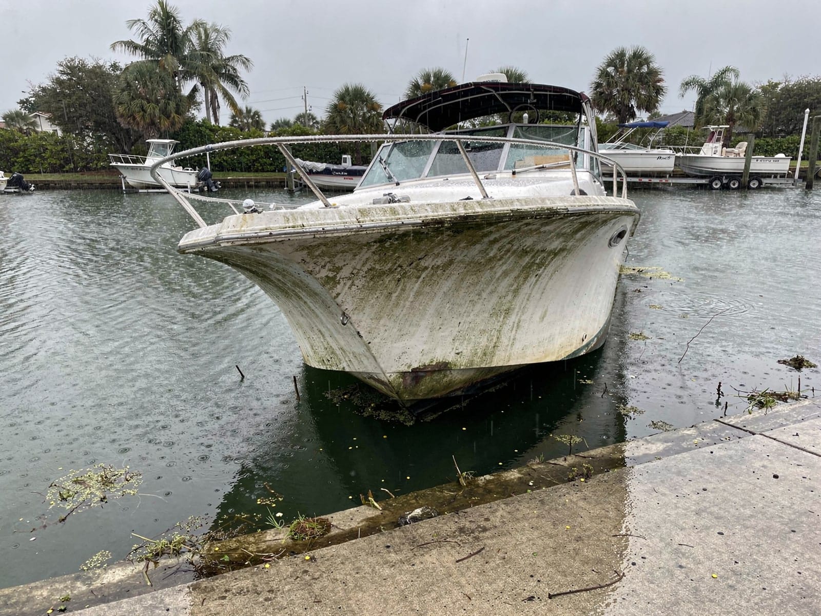Sunken boat recovery in Greenacres, FL: before Sunken 28 ft Bertram 28 by a boat ramp in Greenacres, FL