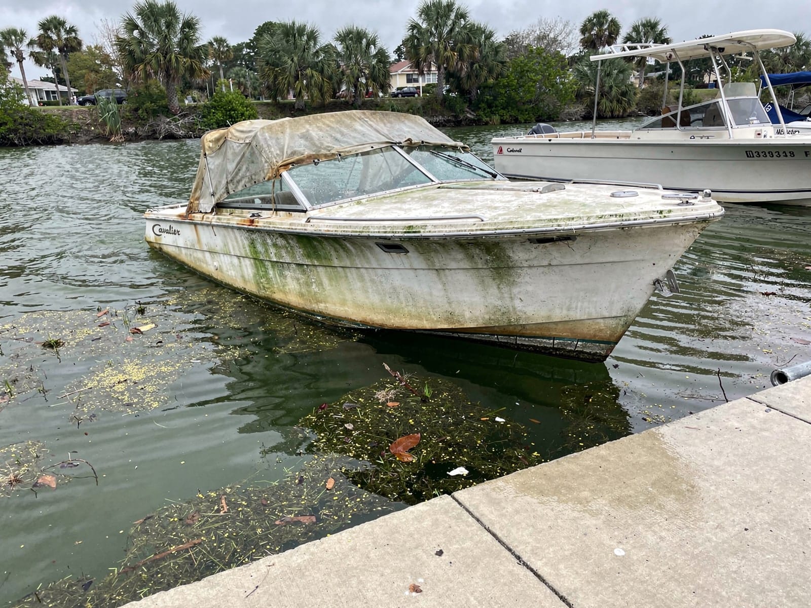 Sunken boat recovery in Holly Hill, FL: before Sunken 23 ft Chris-Craft Cavalier by a boat ramp in Holly Hill, FL
