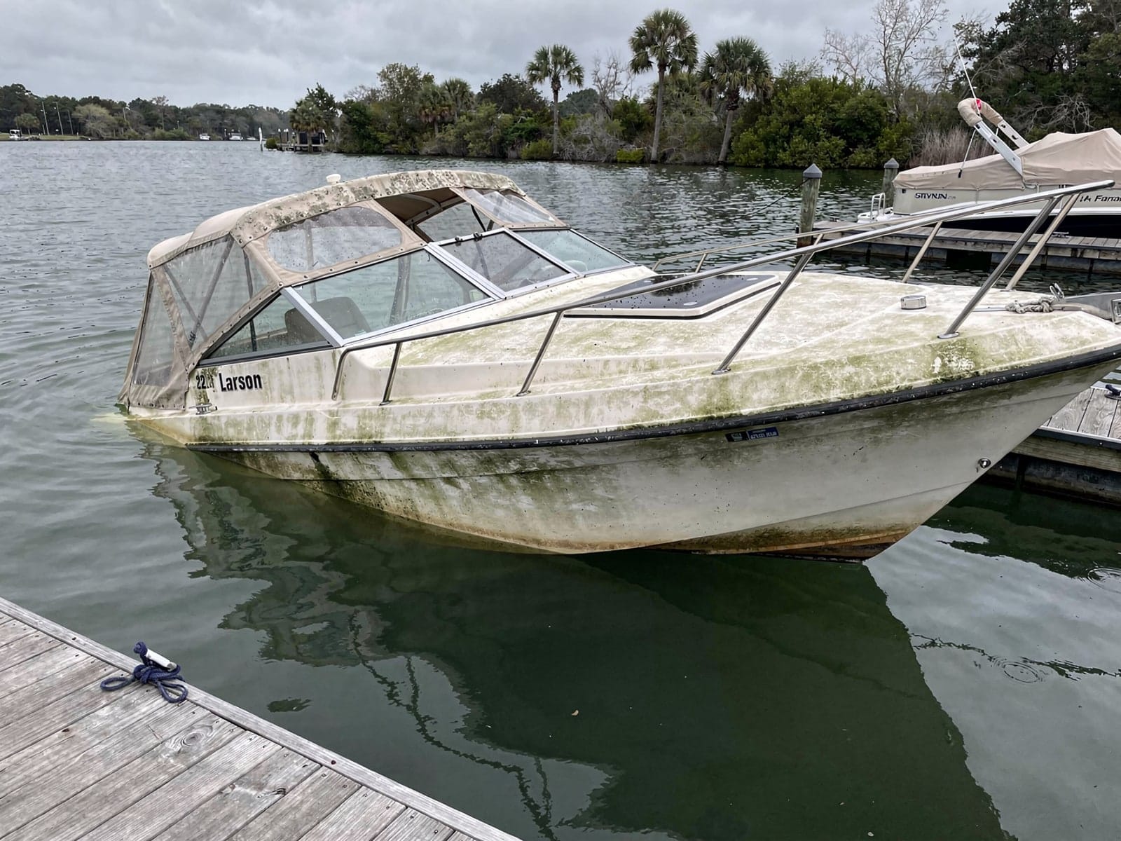 Sunken boat recovery in Sunrise, FL: before Sunken 22 ft Larson 220 at a lake dock in Sunrise, FL