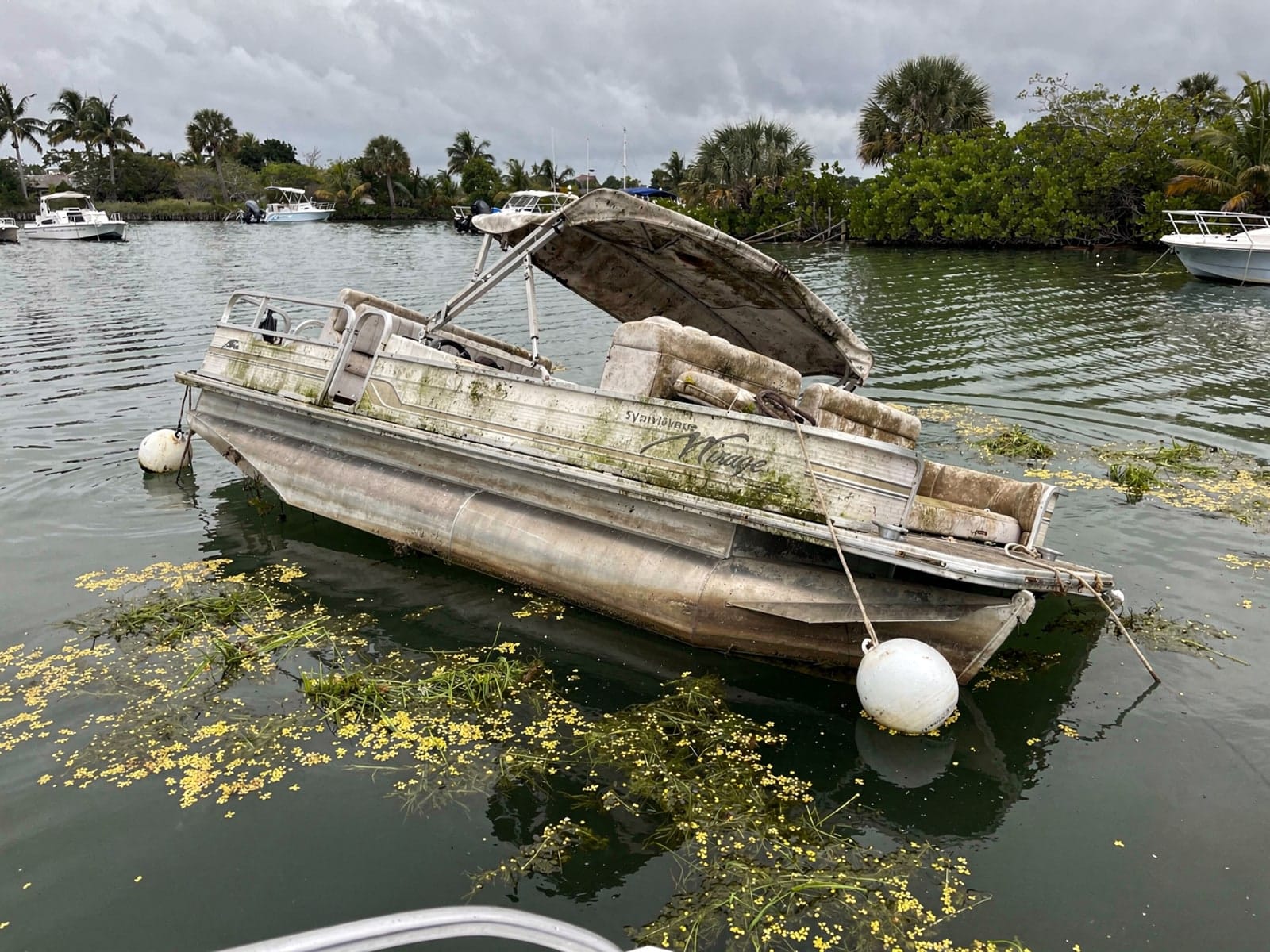 Sunken boat recovery in Tamarac, FL: before Sunken 20 ft Sylvan Mirage 20 at its mooring in Tamarac, FL