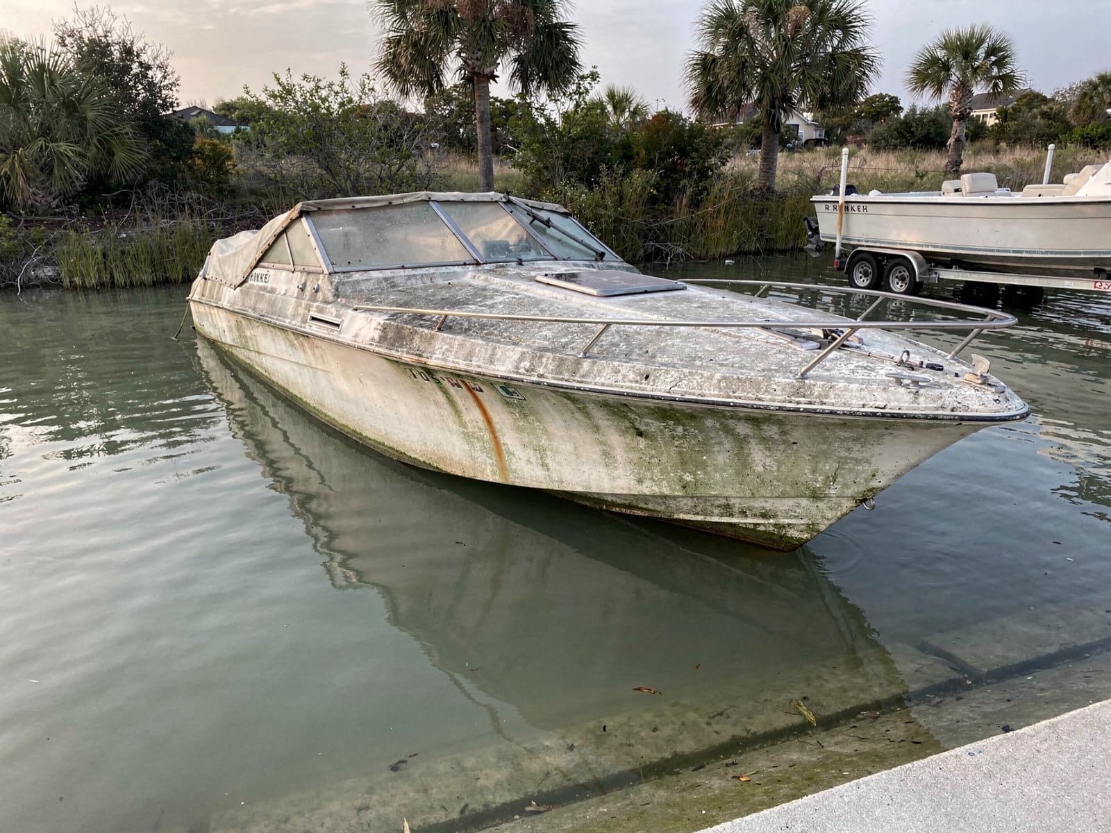 Sunken 23 ft Rinker 232 by a boat ramp in Tampa, FL