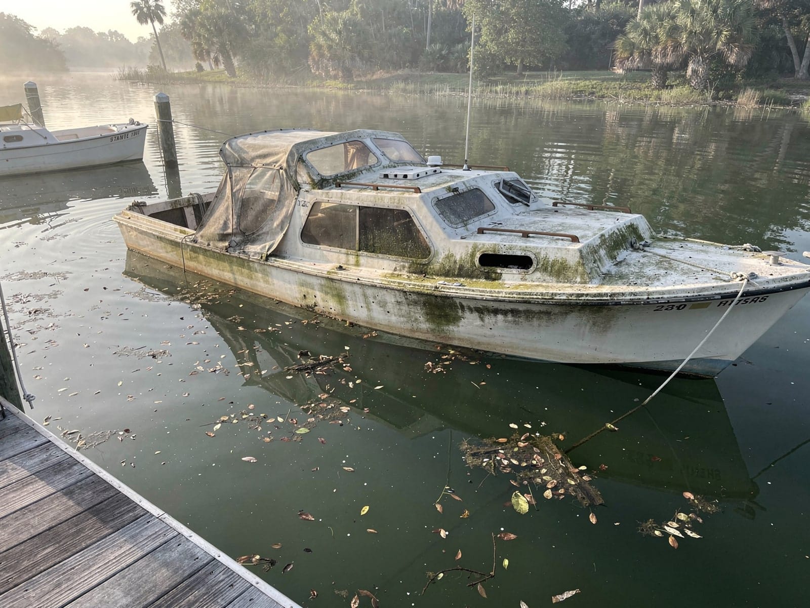 Sunken 26 ft MacGregor 26 at a lake dock in The Villages, FL