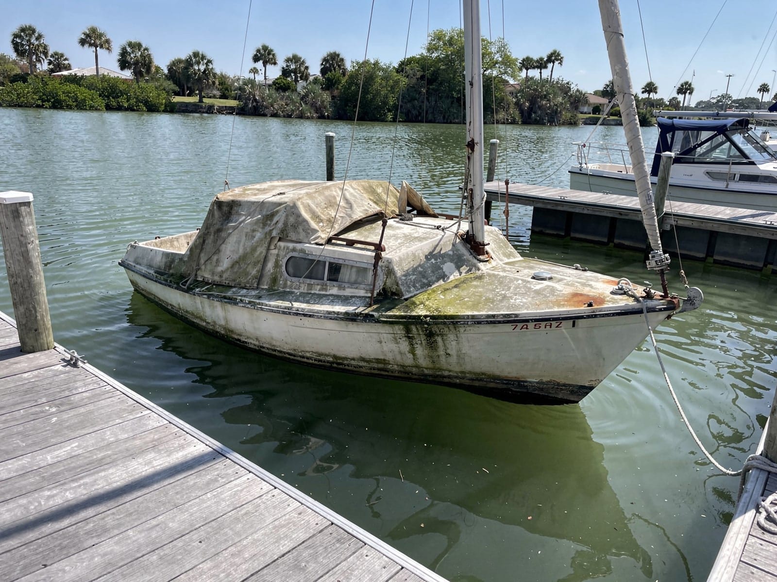 Sunken boat recovery in Aventura, FL: before Sunken 27 ft Cal 27 at a lake dock in Aventura, FL