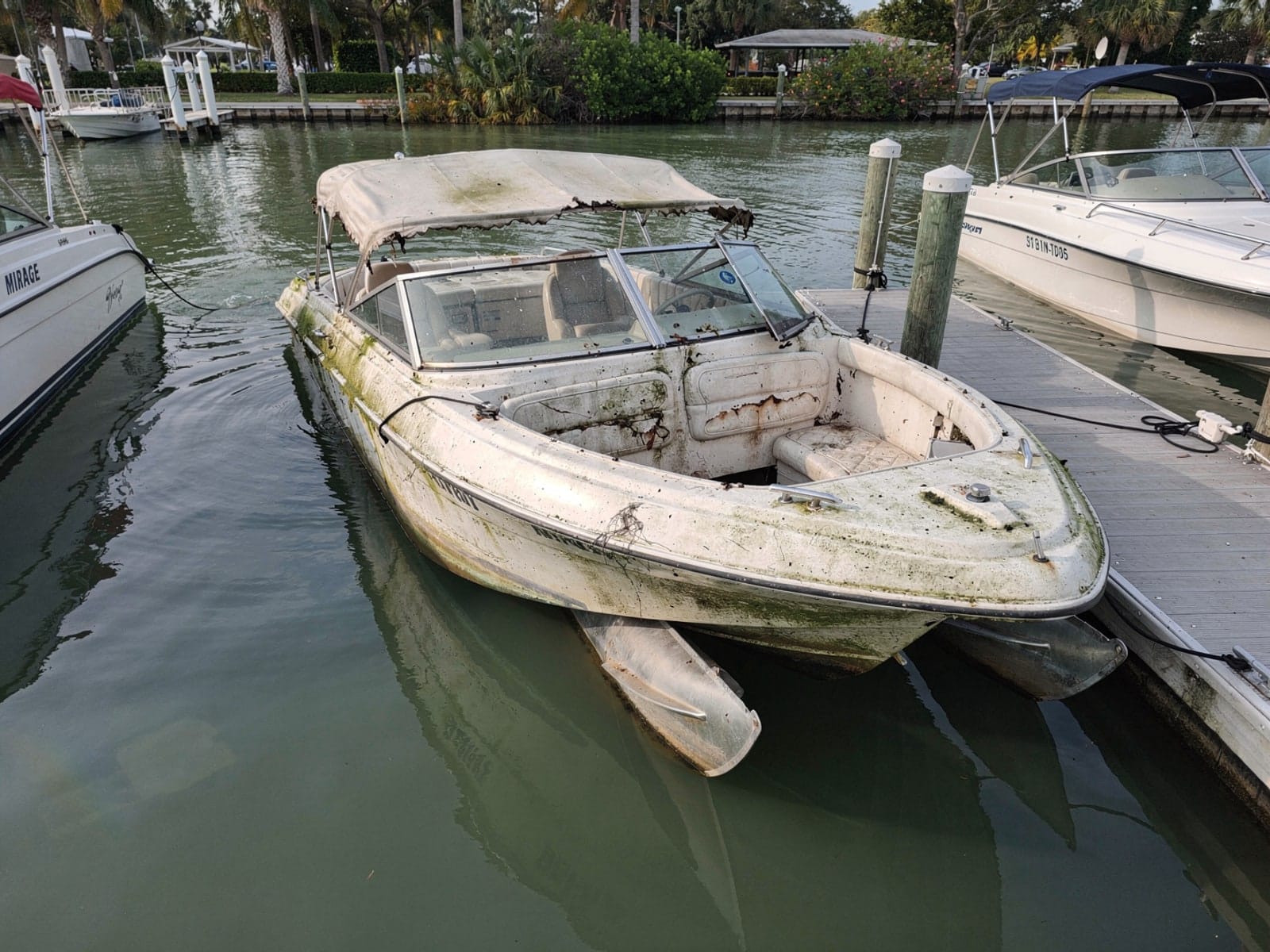 Sunken boat recovery in Bradenton, FL: before Sunken 20 ft Sylvan Mirage 20 in a marina slip in Bradenton, FL