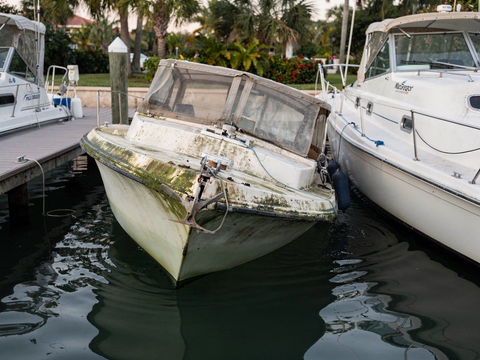 Sunken boat recovery in Coral Springs, FL: before Sunken 26 ft MacGregor 26 in a marina slip in Coral Springs, FL
