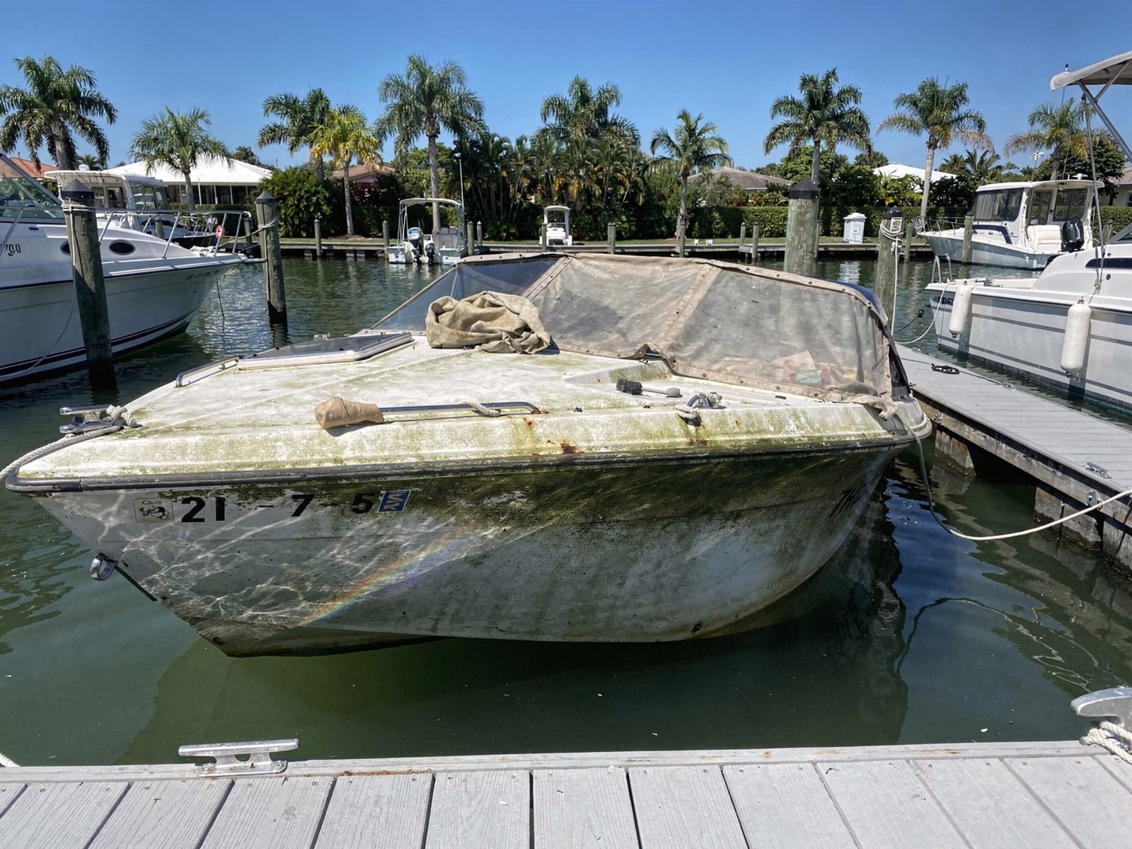 Sunken boat recovery in Hialeah, FL: before Sunken 21 ft Thompson 21 in a marina slip in Hialeah, FL