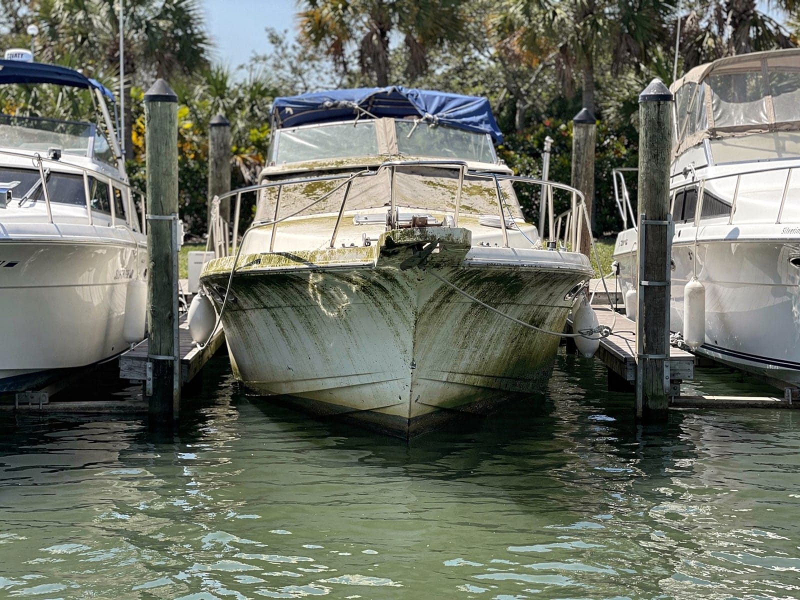 Sunken boat recovery in Progress Village, FL: before Sunken 34 ft Silverton 34 in a marina slip in Progress Village, FL