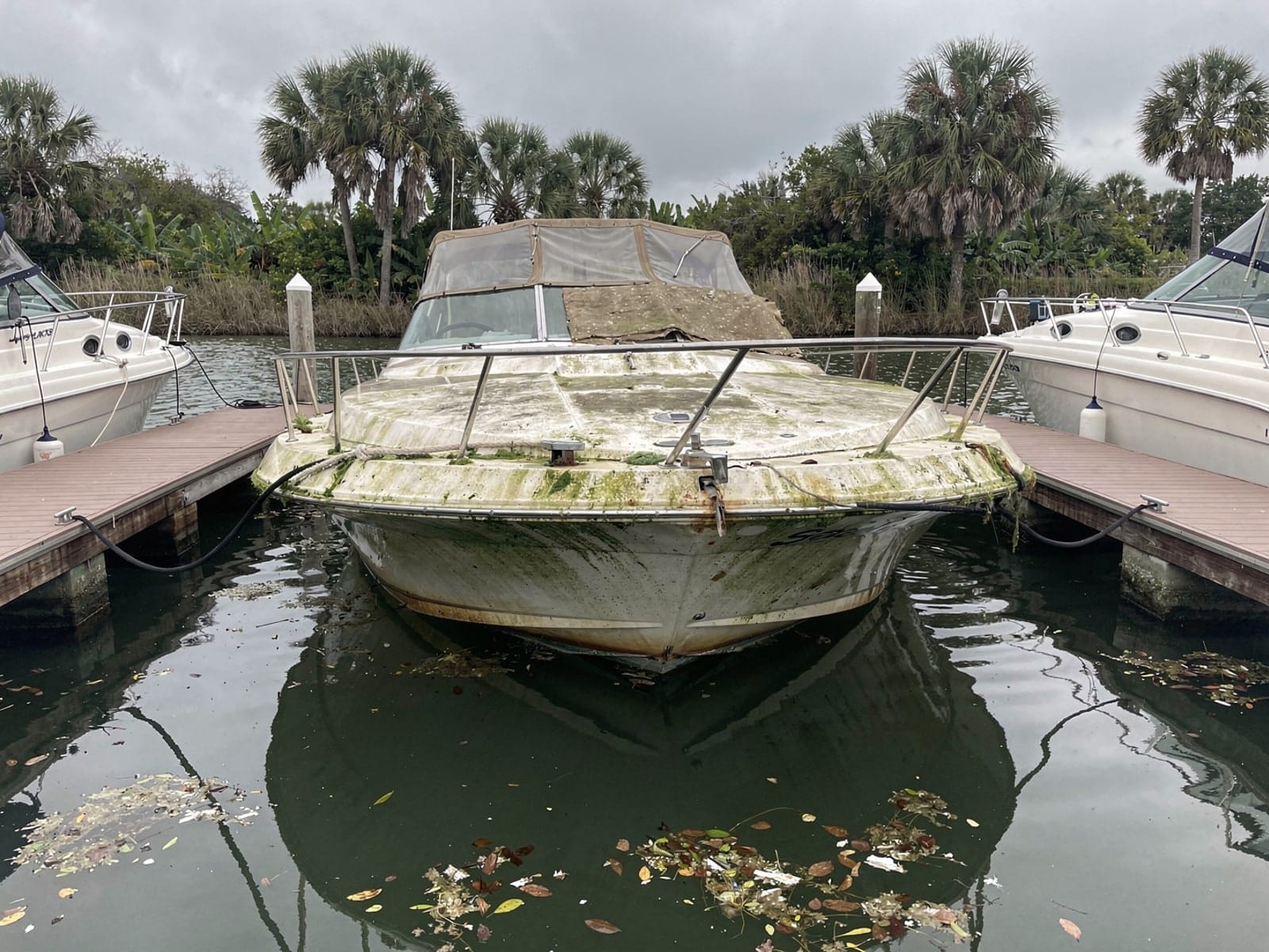 Sunken boat recovery in The Hammocks, FL: before Sunken 26 ft Sea Ray 268 Sundancer in a marina slip in The Hammocks, FL