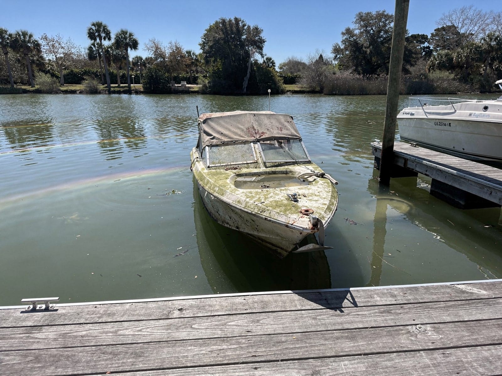 Sunken 22 ft Larson 220 at a lake dock in Wildwood, FL