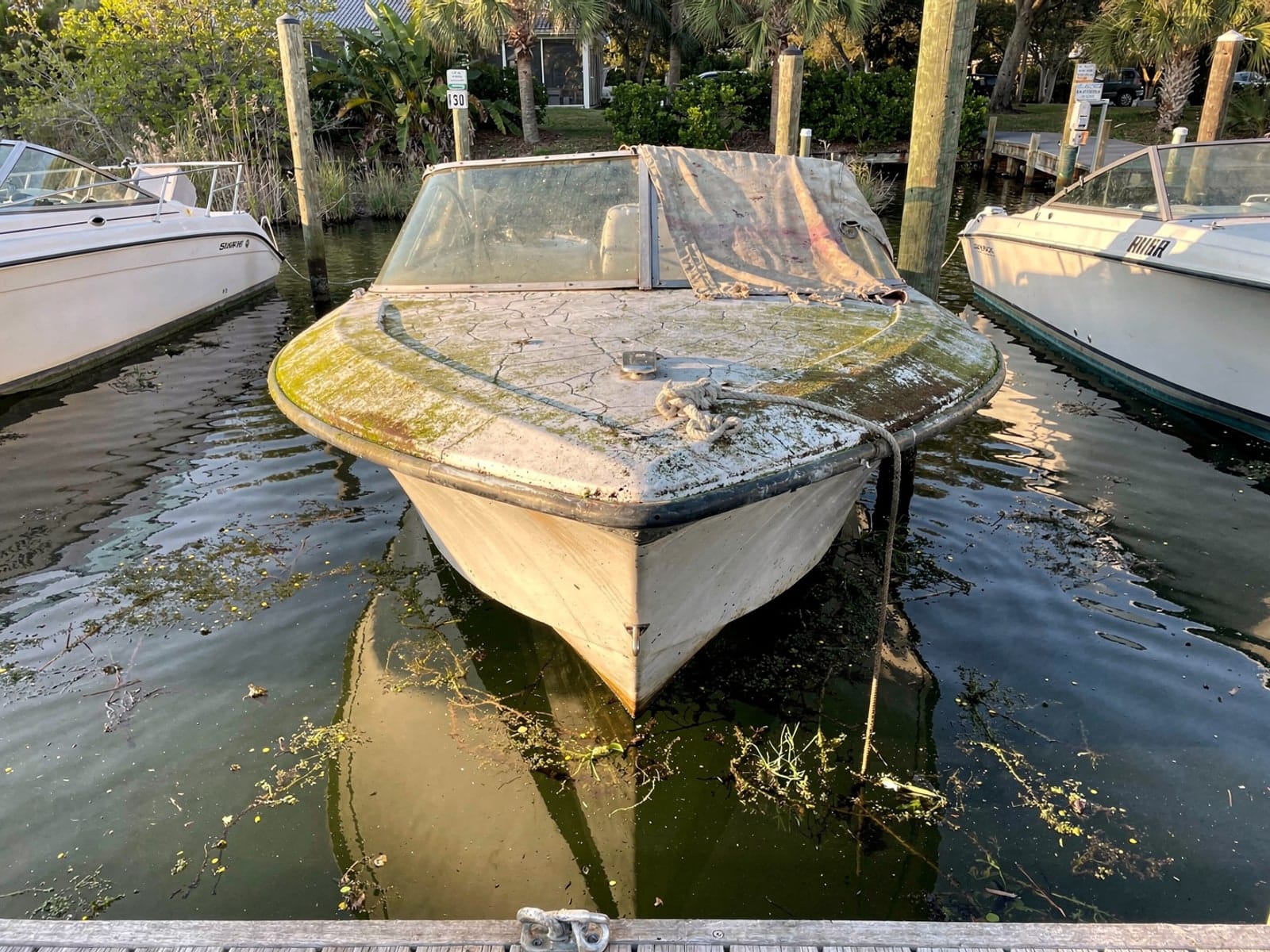 Sunken 23 ft Rinker 232 in a marina slip in Wesley Chapel, FL